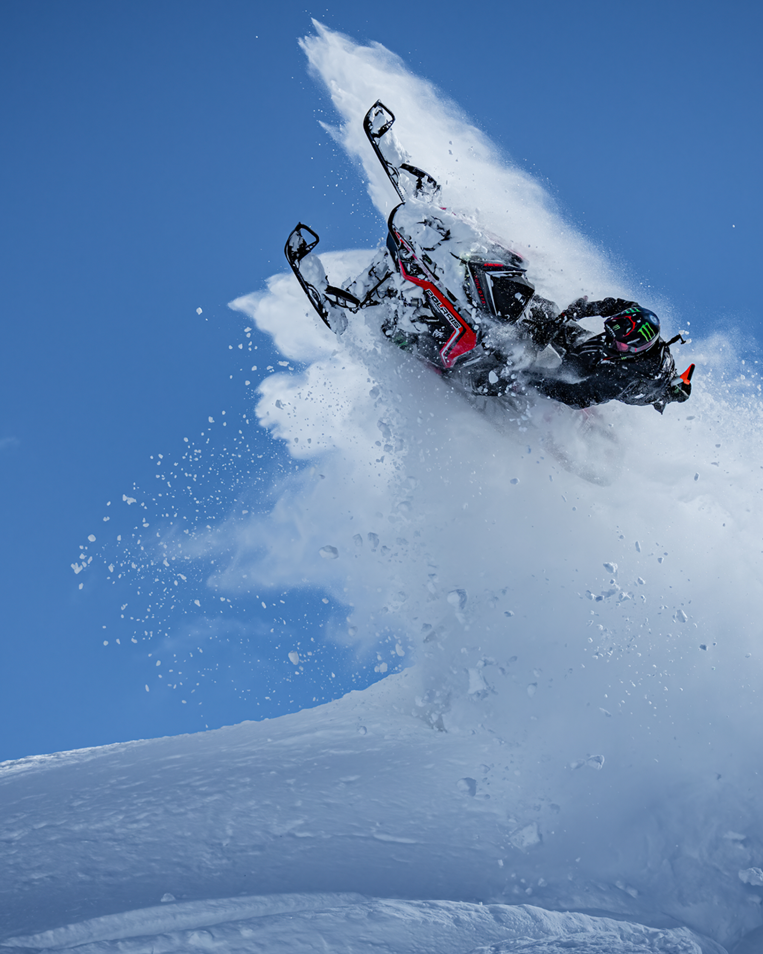 Snowmobile in the mountains doing tricks