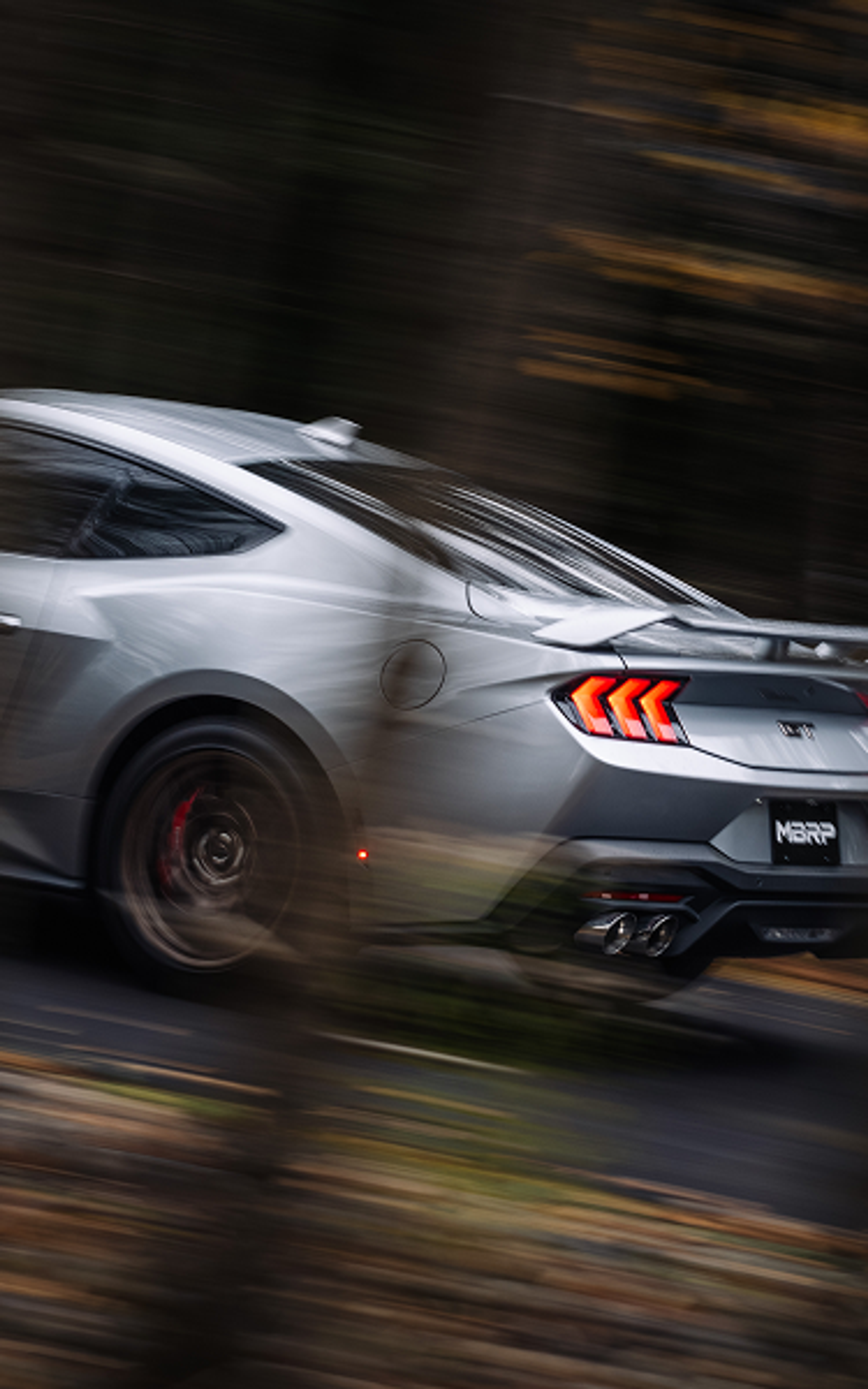 Silver GT Mustang with MBRP exhaust driving fast