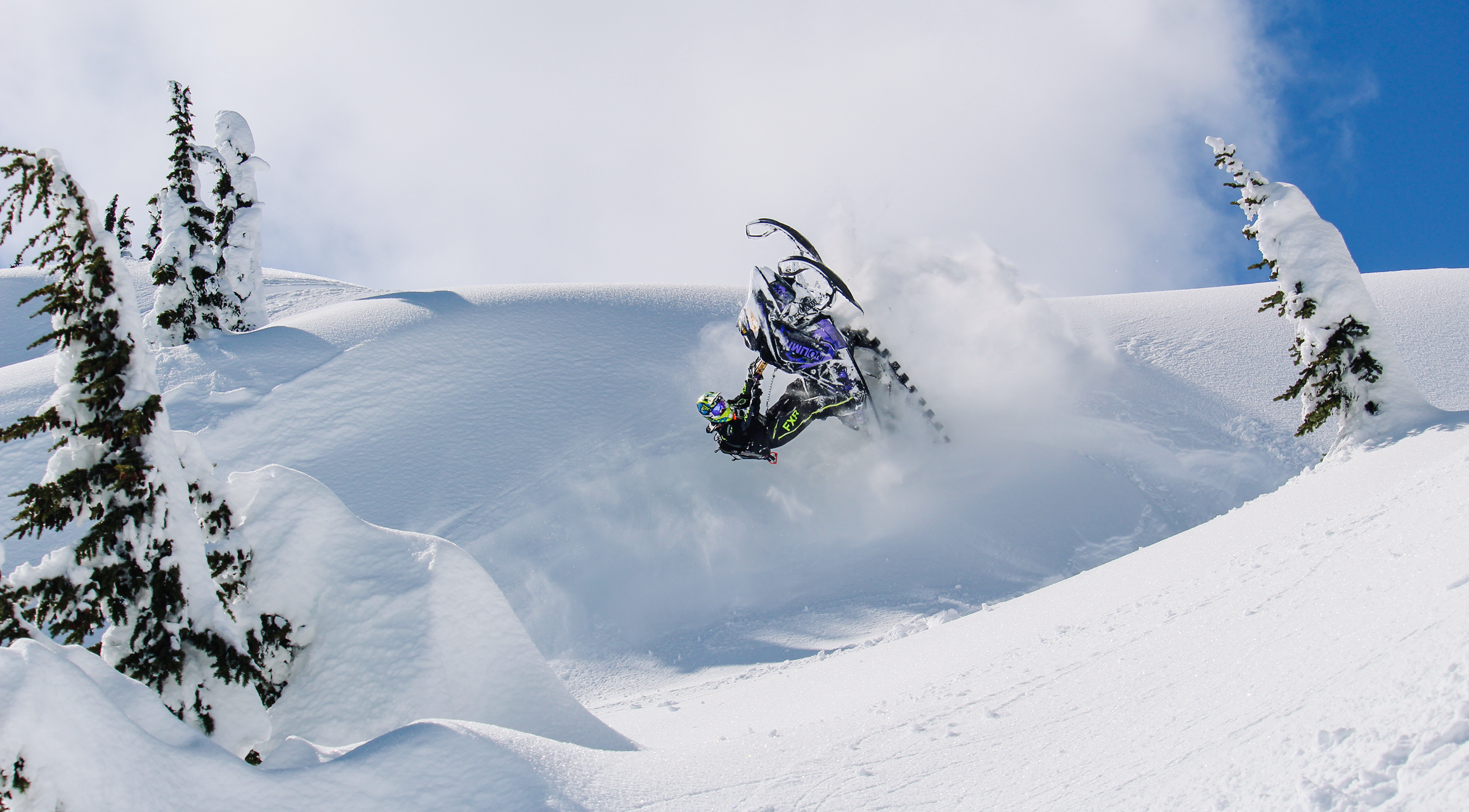 Snowmobile in the mountains doing tricks
