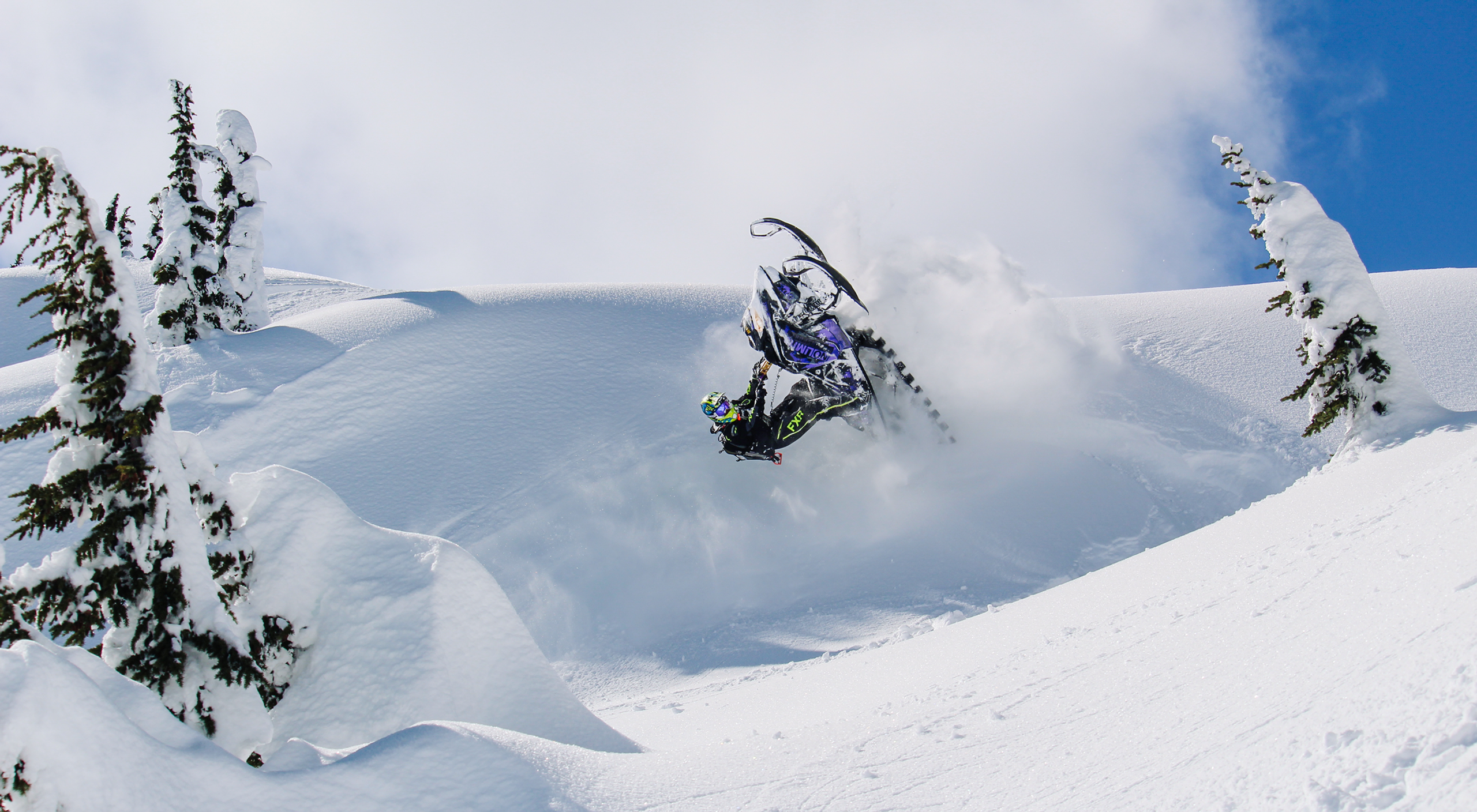 Snowmobile in the mountains doing tricks