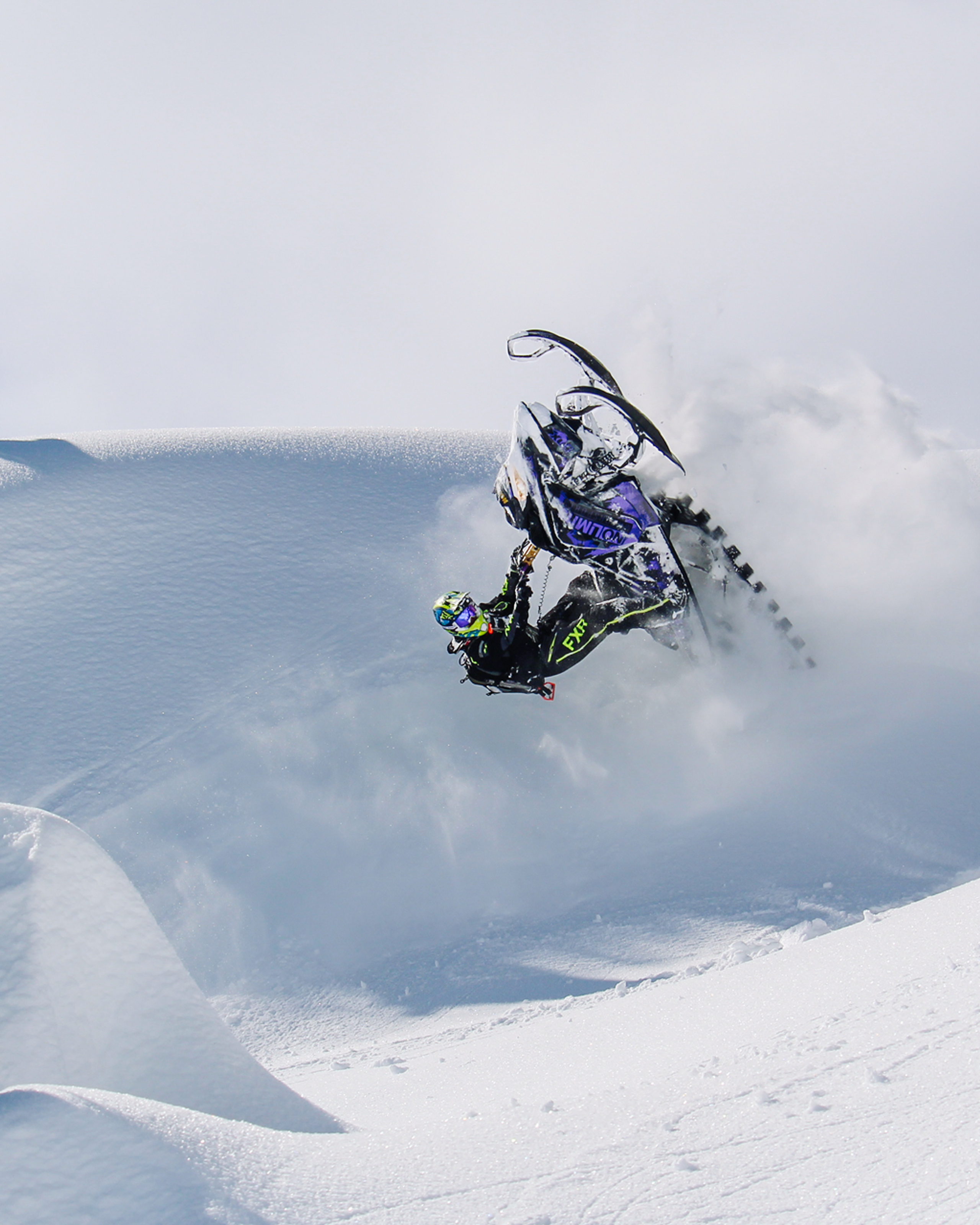 Snowmobile in the mountains doing tricks