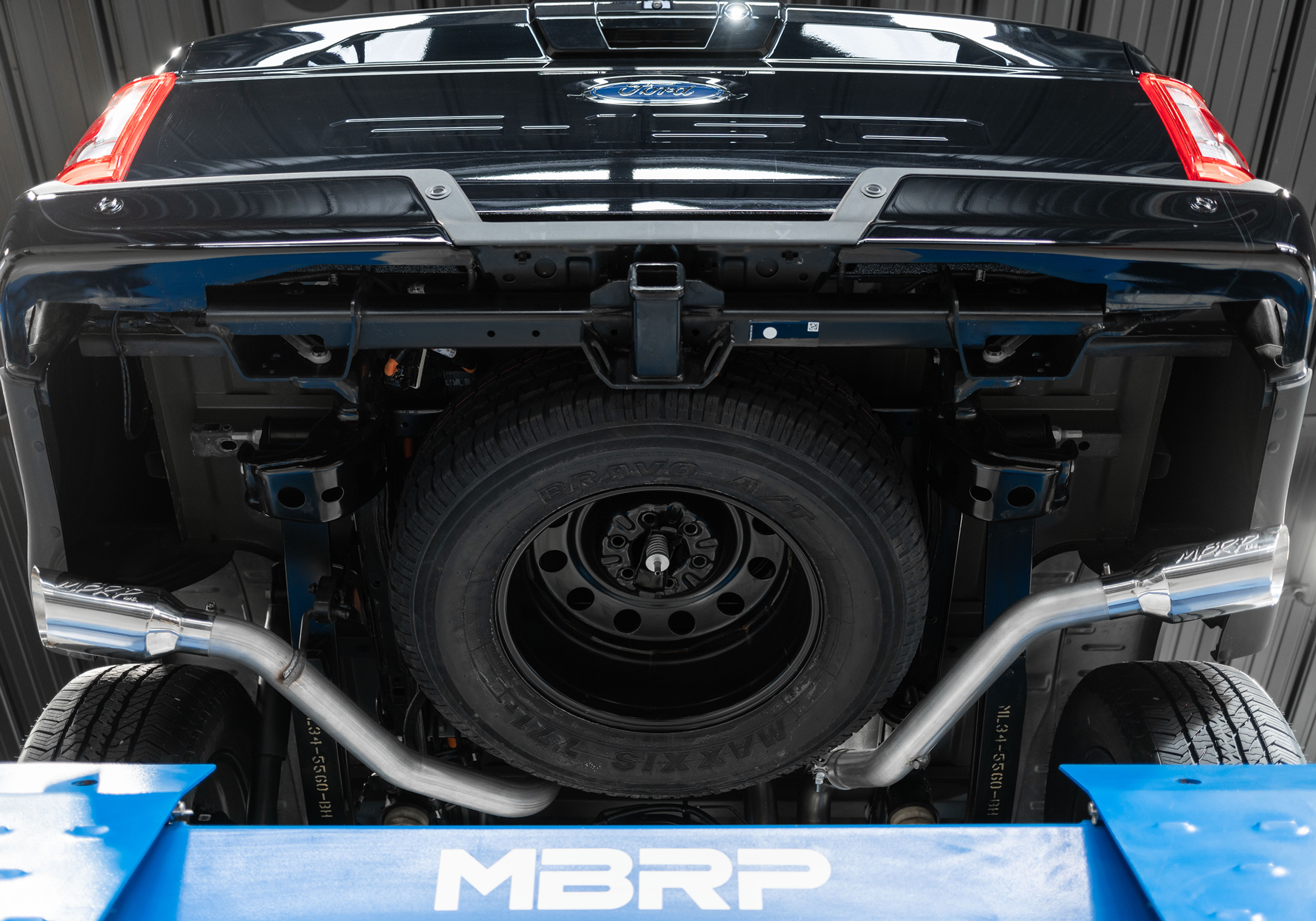 Black Ford F-150 on the hoist after an mbrp dual side exit exhaust install