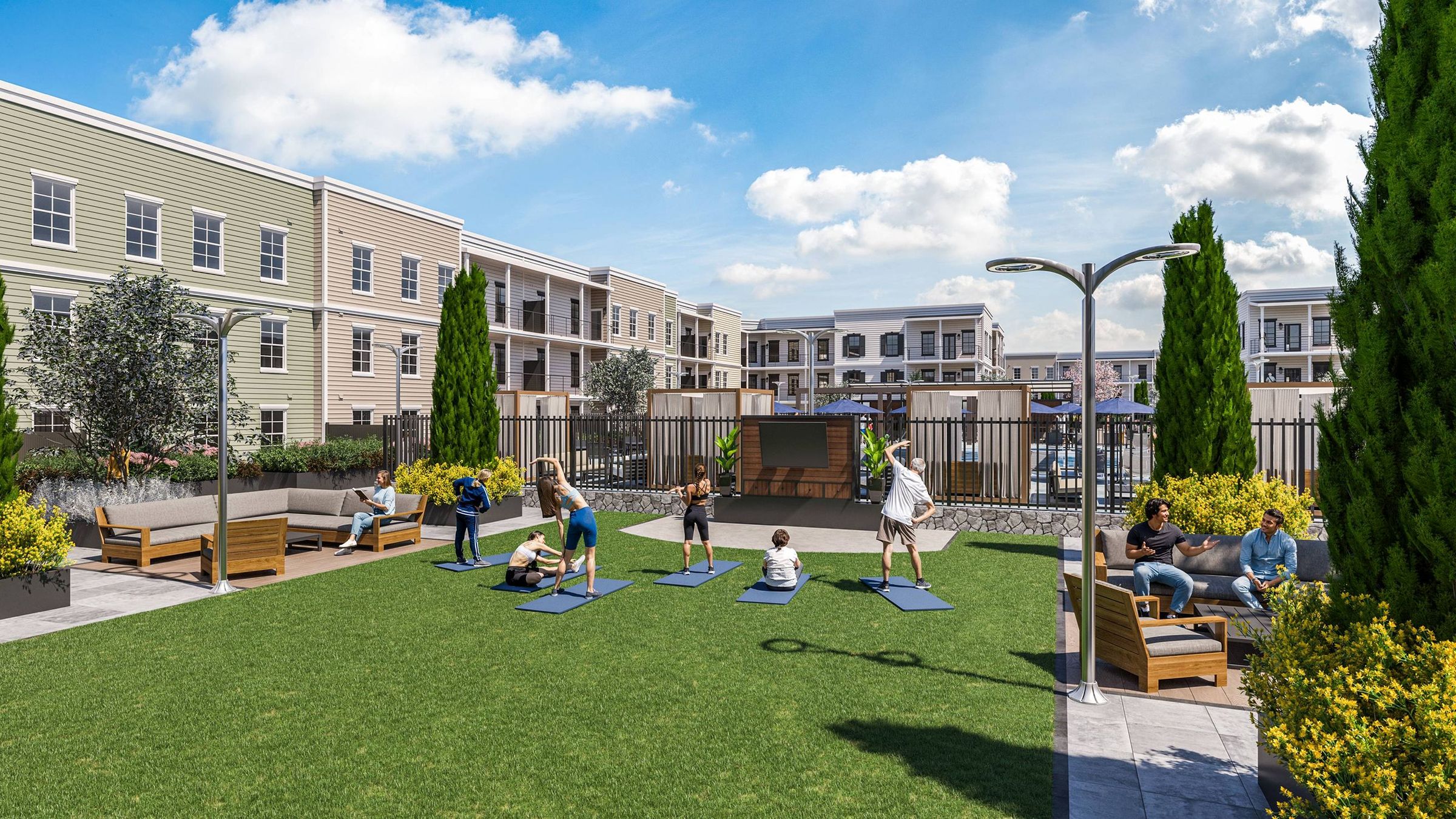People stretching on yoga mats in a grassy courtyard surrounded by apartment buildings and seating.