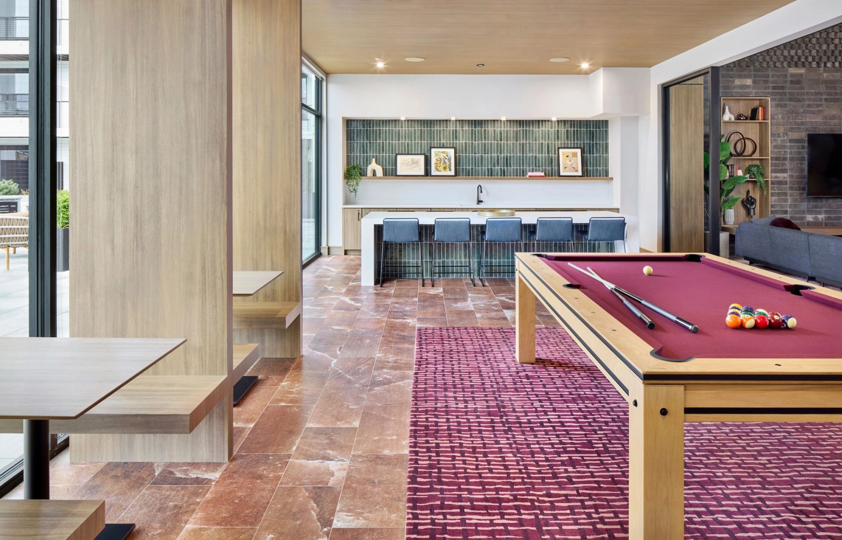 Resident game room featuring a pool table, seating areas, dining tables, and a large island and bar seating.