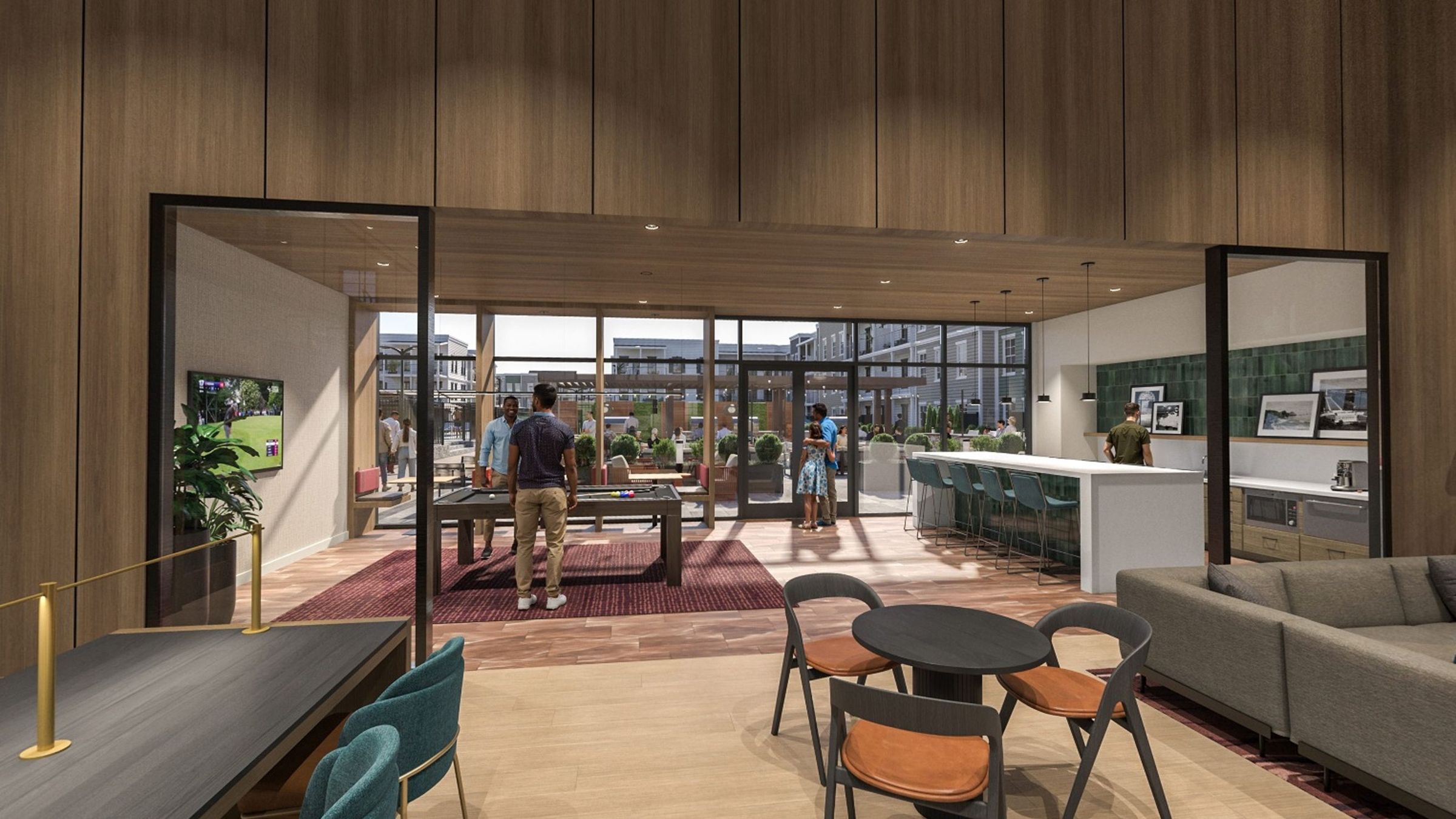 Modern lounge with people playing pool, chatting, and using a kitchen in a bright open space.
