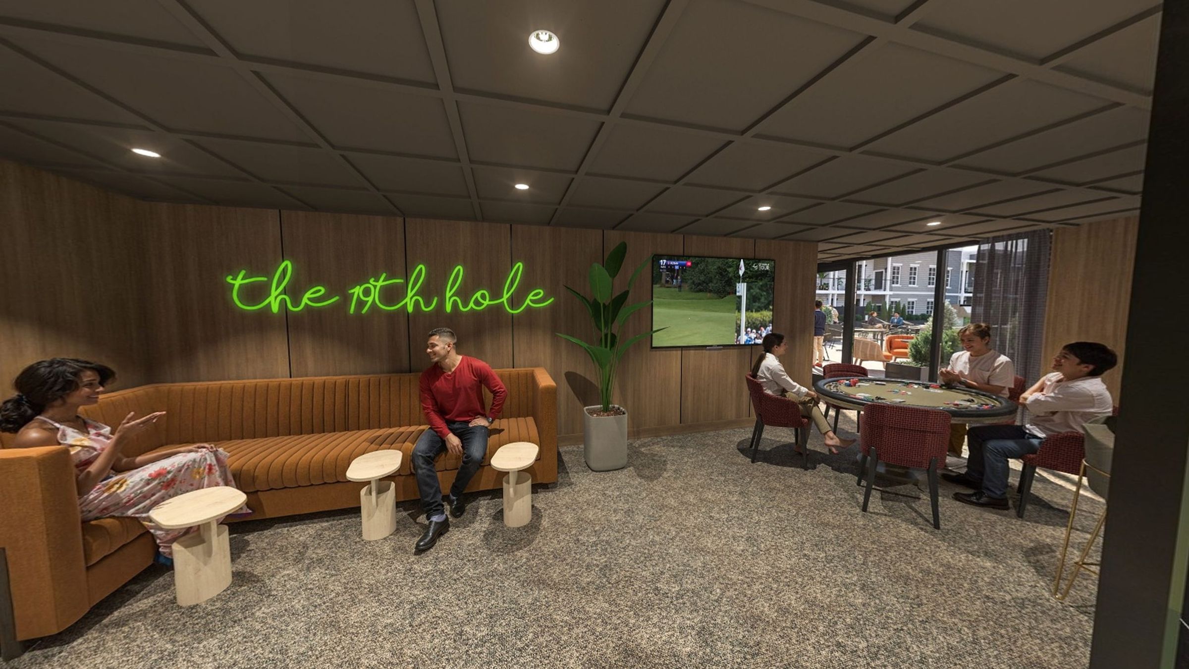 Relaxing lounge space with big-screen TVs, cozy seating, and a poker table.