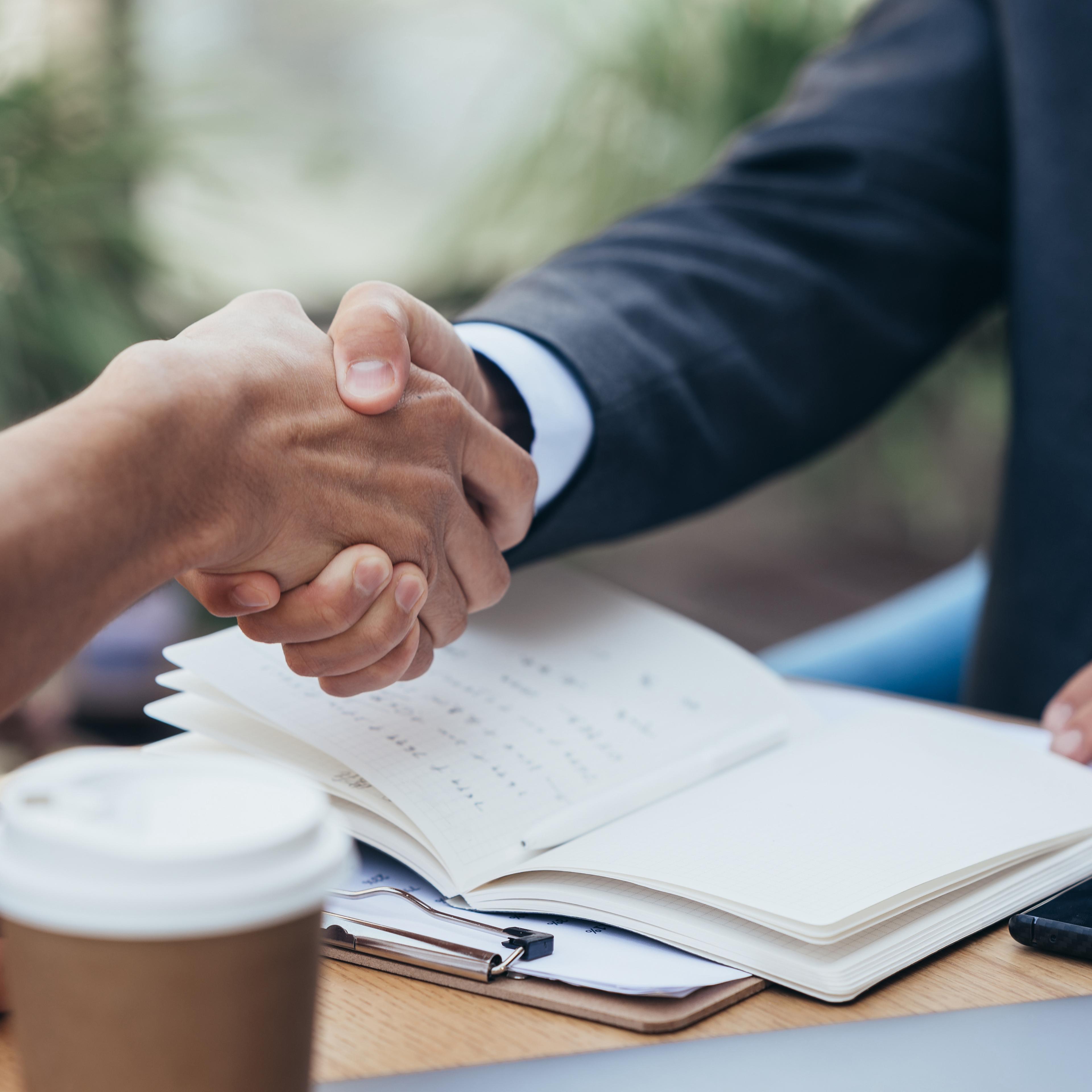 Two people shaking hands during a meeting
