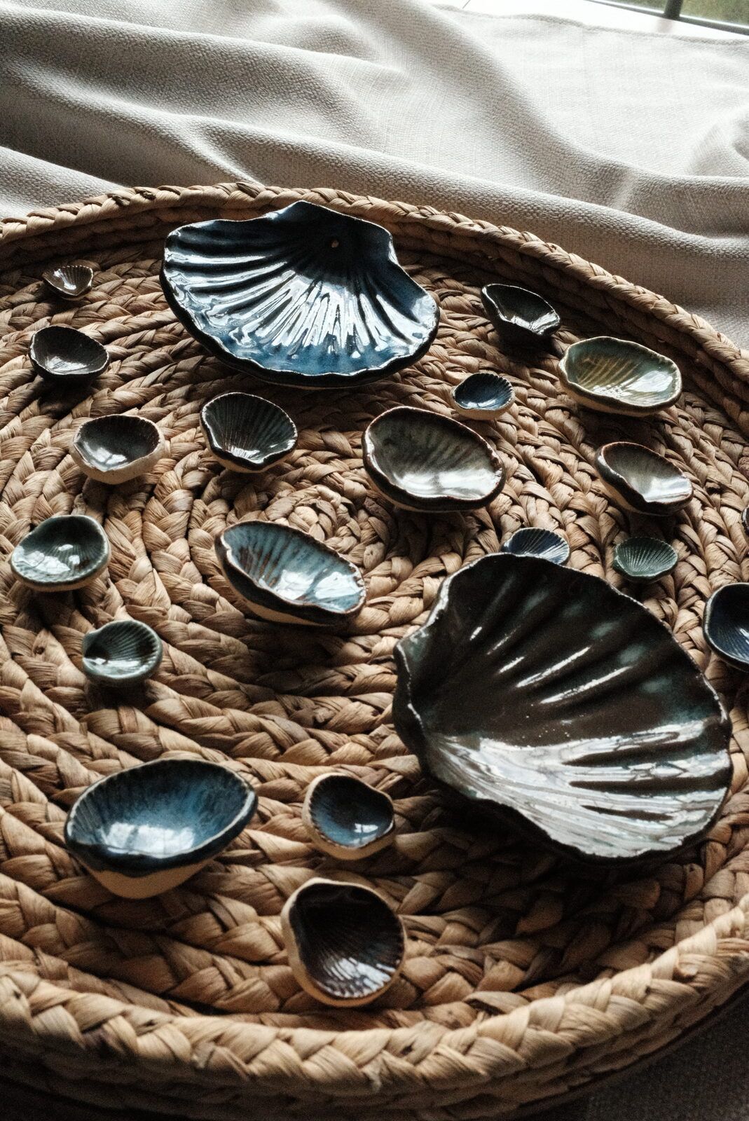 Kelly's blue-glazed ceramic seashell dishes arranged on a round woven tray