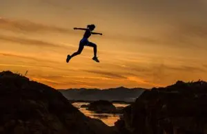 Person doing a high mobility jump against a stunning sunset backdrop