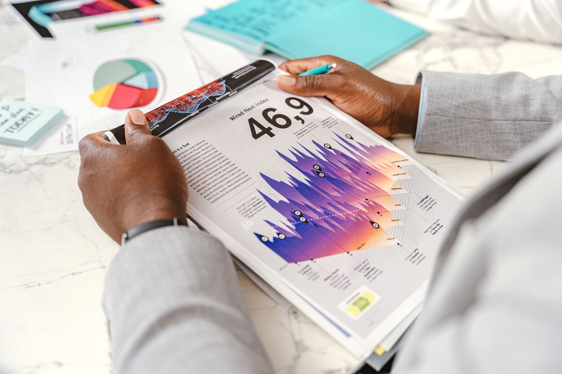 Person reading a printed report full of colorful charts