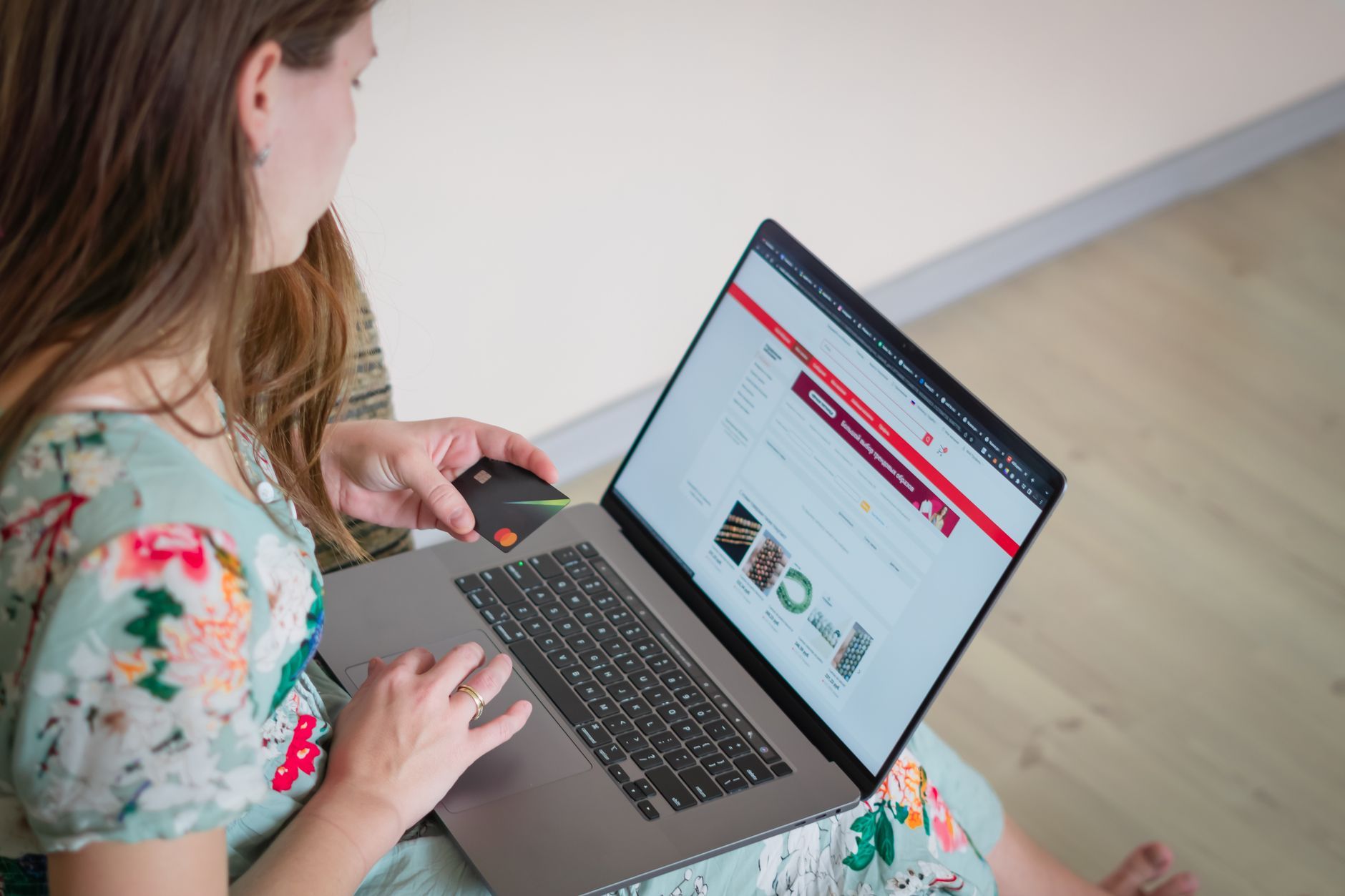 Woman shopping on a laptop while holding a payment card