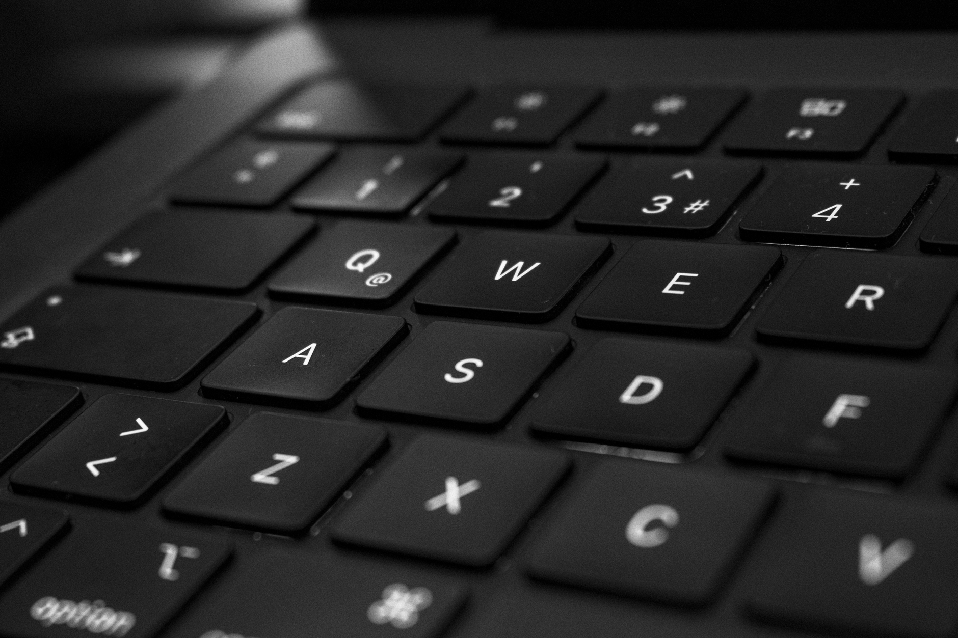 Close-up of a dark backlit laptop keyboard