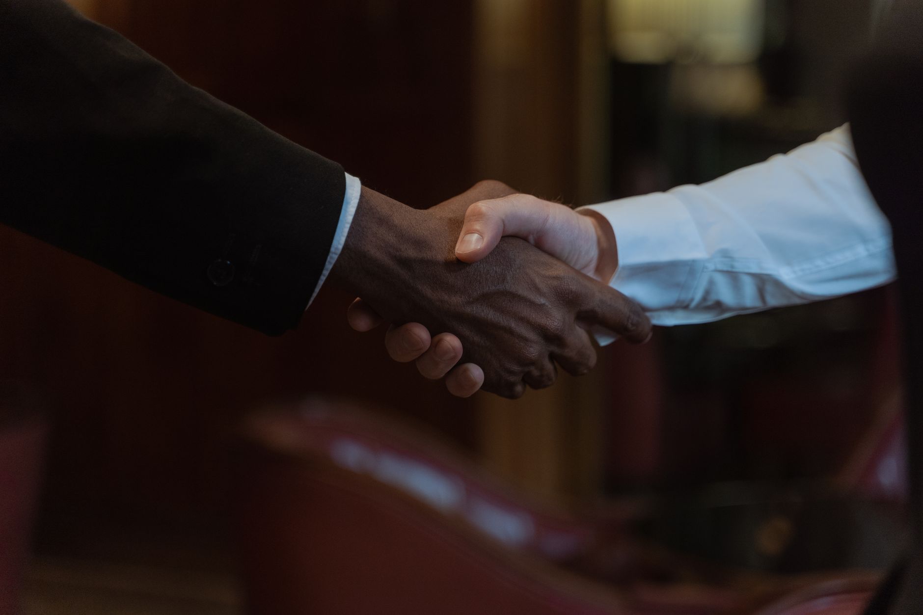 Two people shaking hands in a warm office setting