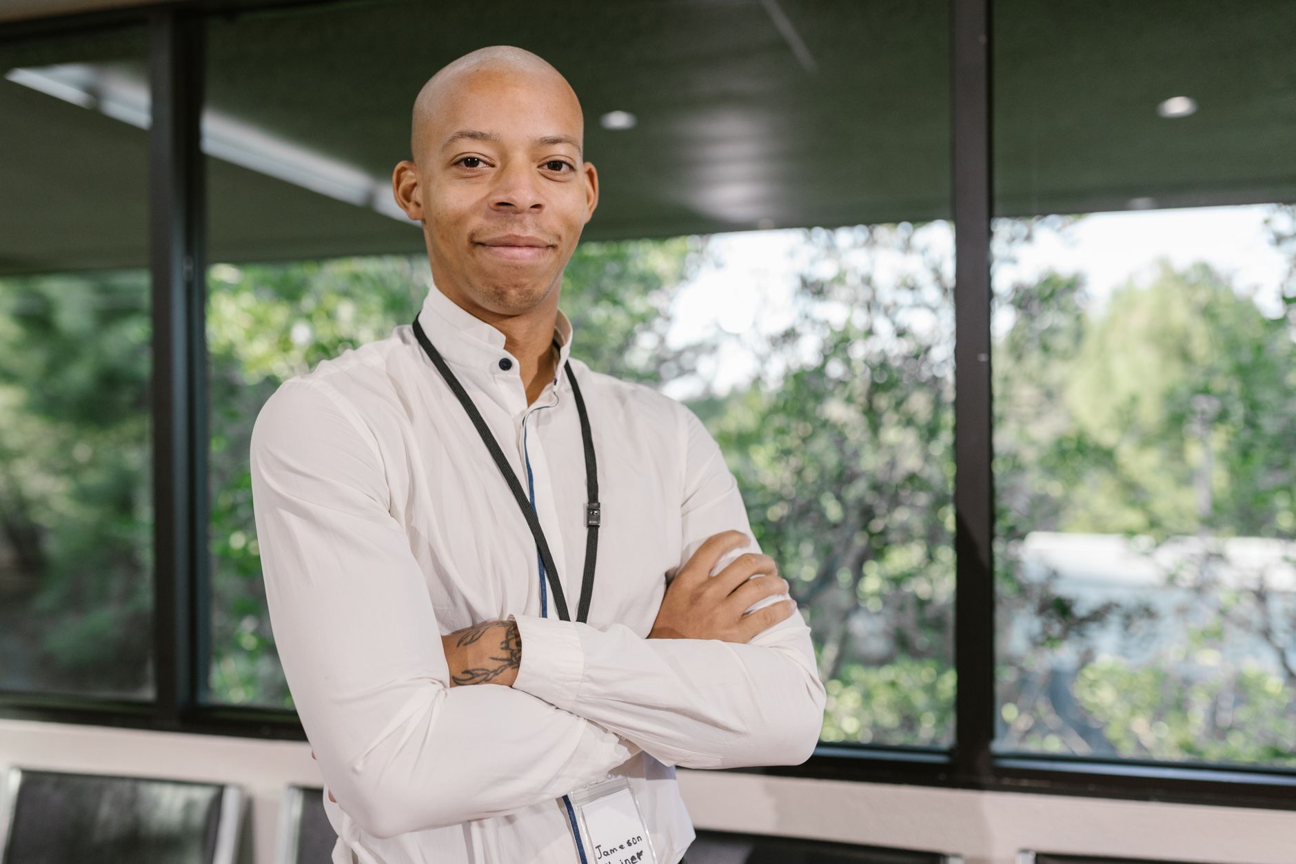 Confident professional standing with arms crossed in a bright office