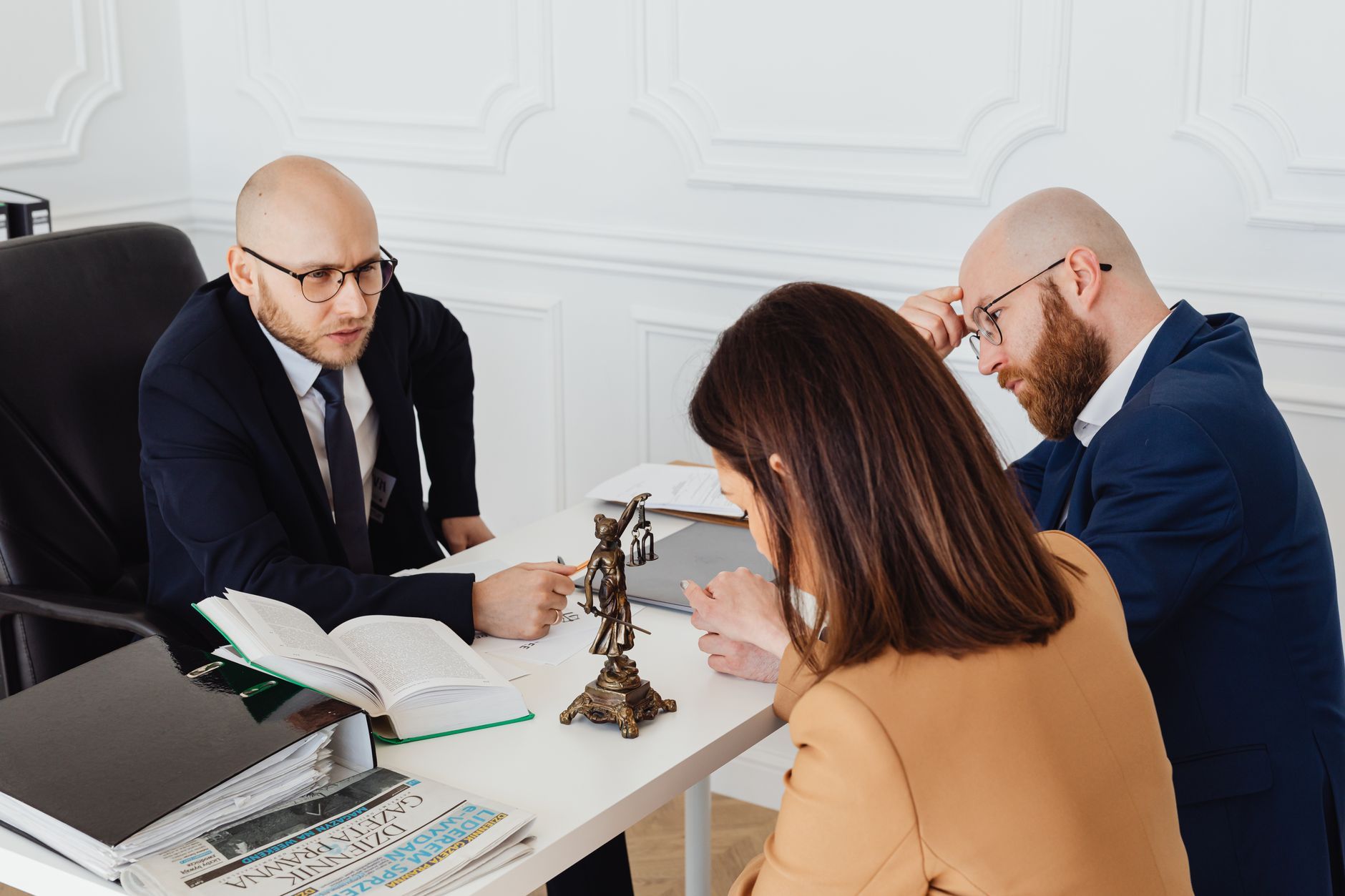 Three professionals reviewing documents together at a conference table