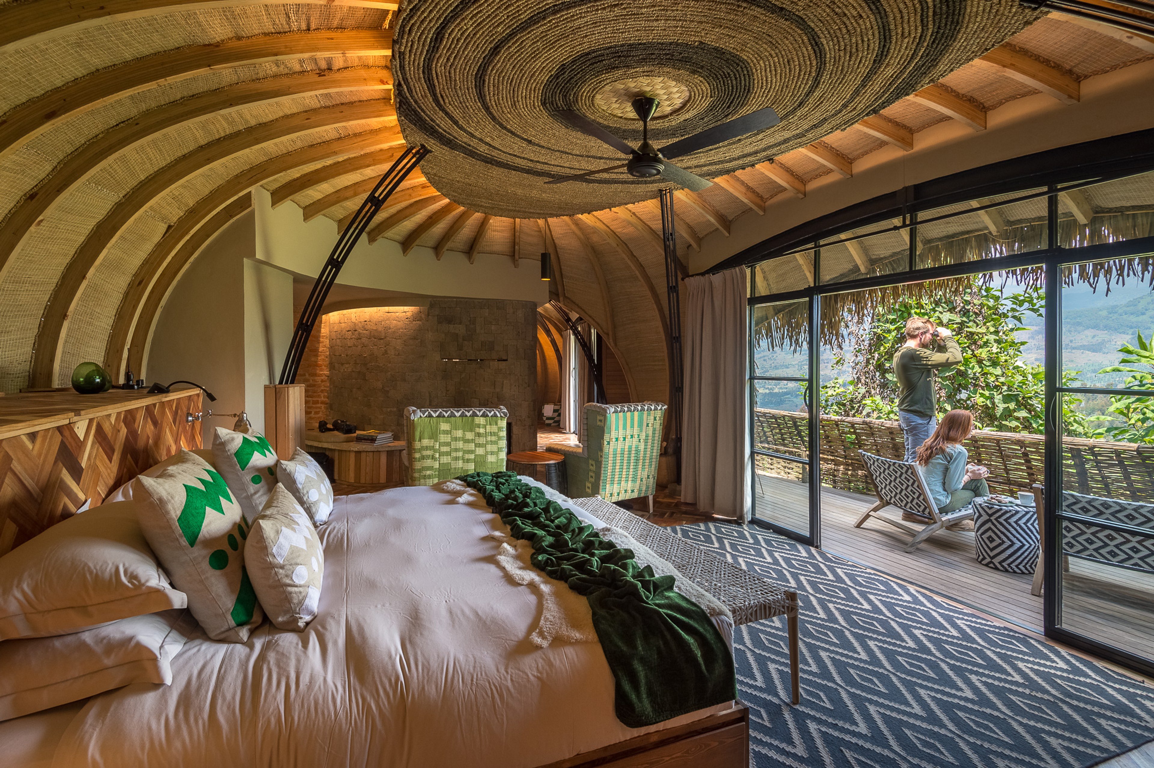 Luxurious guest room with unique wooden architecture, open doors leading to a terrace with mountain views