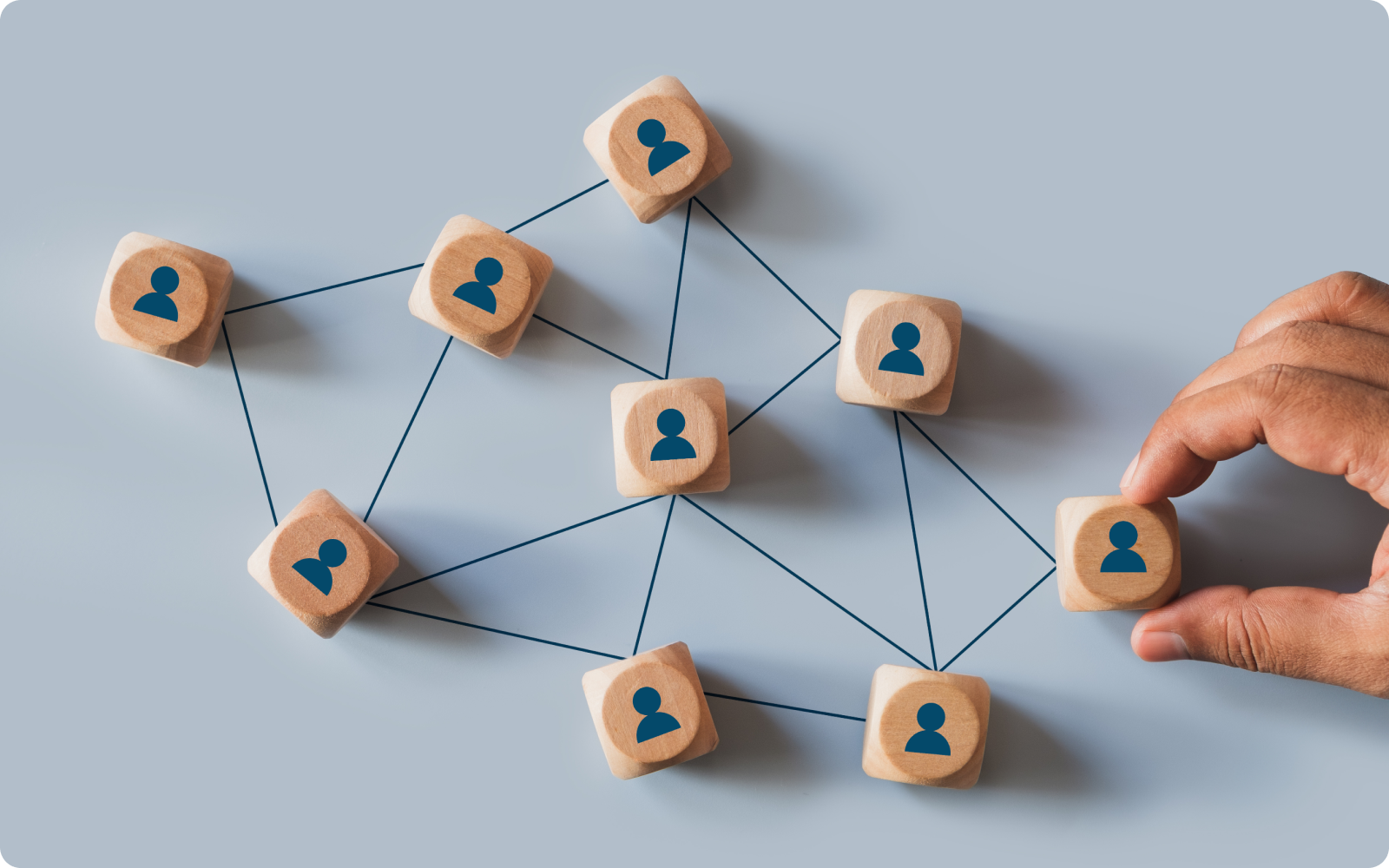 How to start a real estate brokerage desktop illustration with a hand moving wooden game pieces around