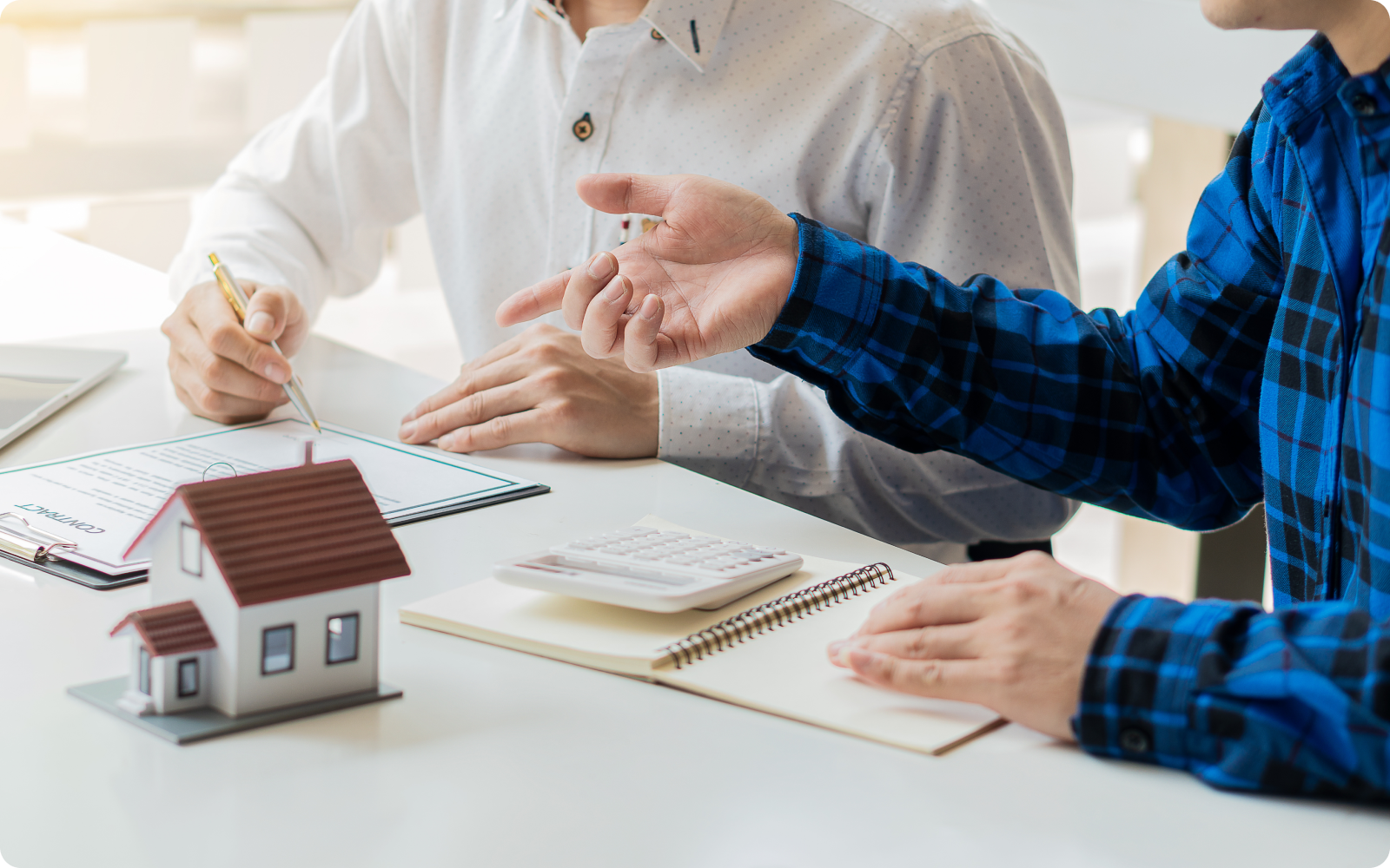 How to start a real estate brokerage agent and client signing paperwork with house model centerpiece