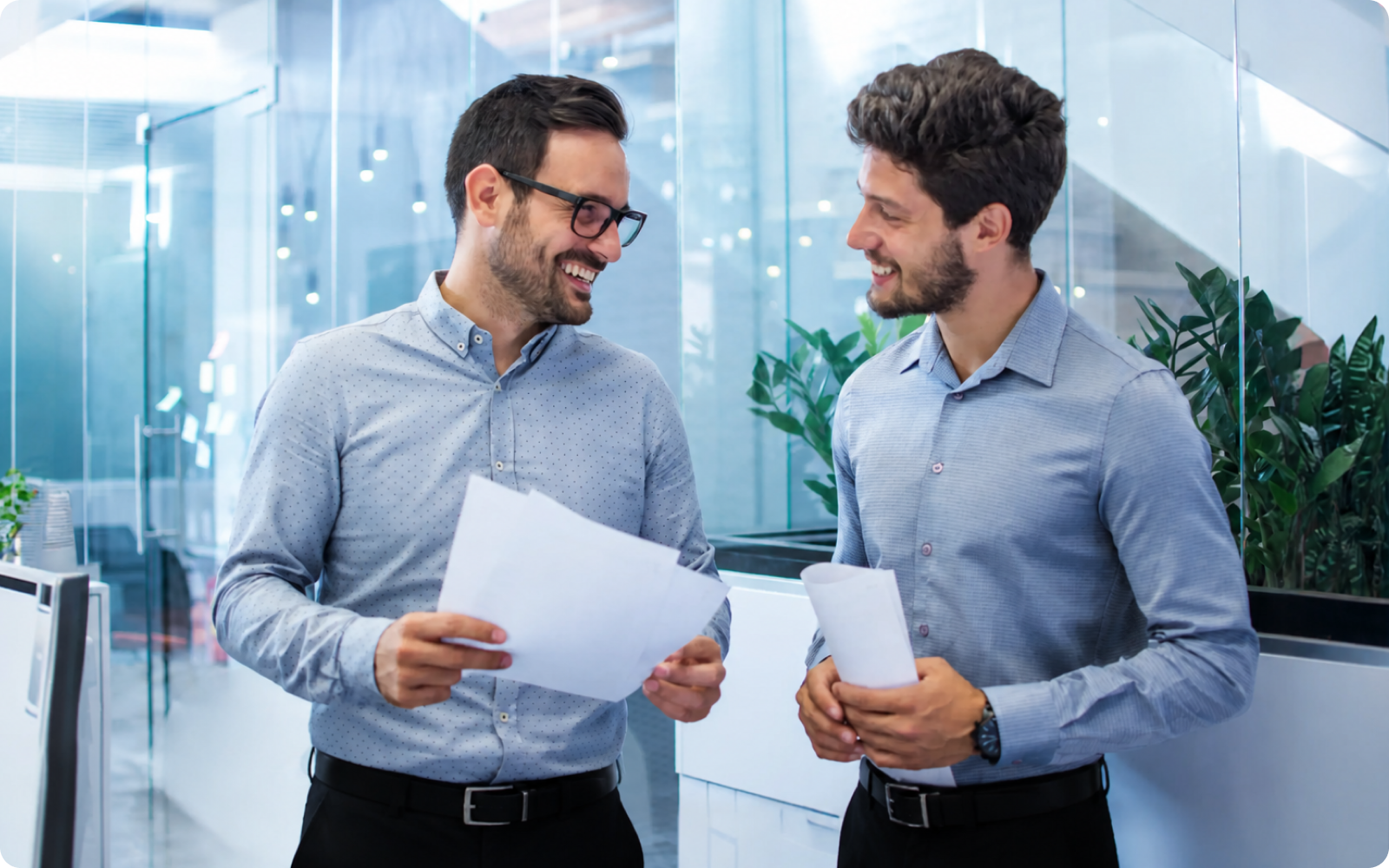 Two realtors looking at paperwork with real estate recruiting software data