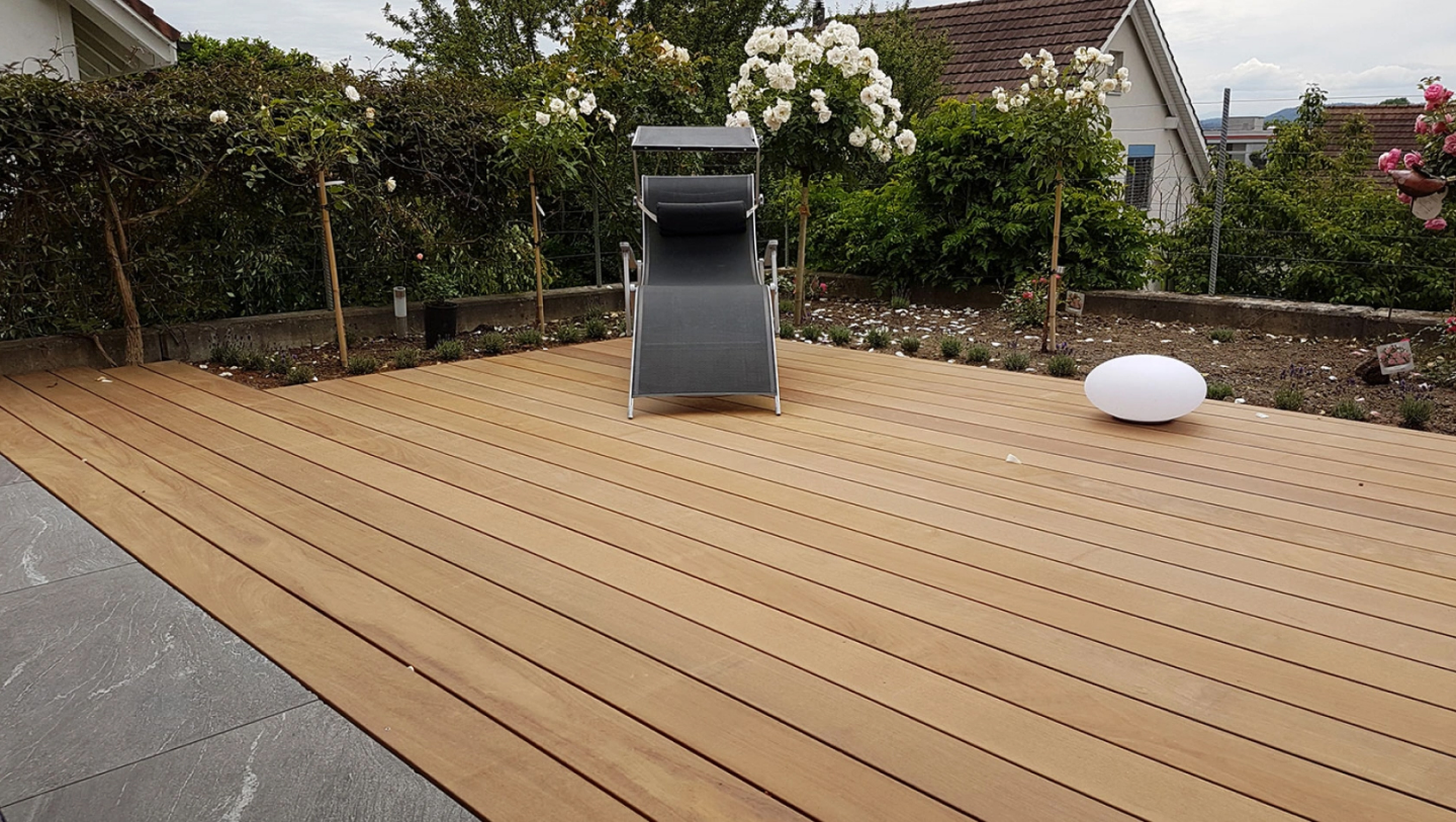 Holzterrasse mit Liegestuhl und Lampe