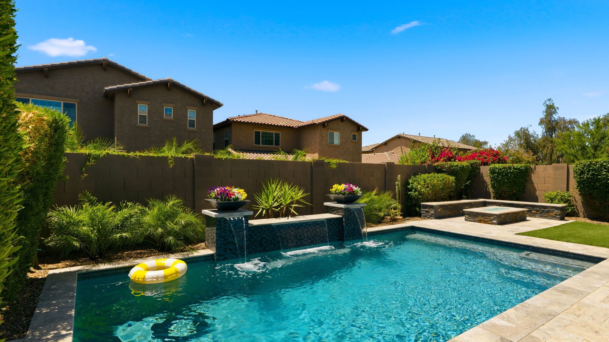 Vista Bonita resort-style backyard with custom pool, water sheet feature, covered patio, and fire pit