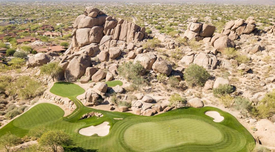 Granite boulder outcrops rising beside the desert course at Whisper Rock