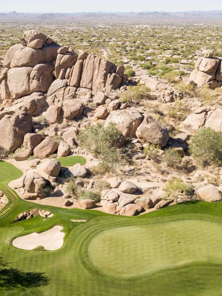 Granite boulder outcrops rising beside the desert course at Whisper Rock