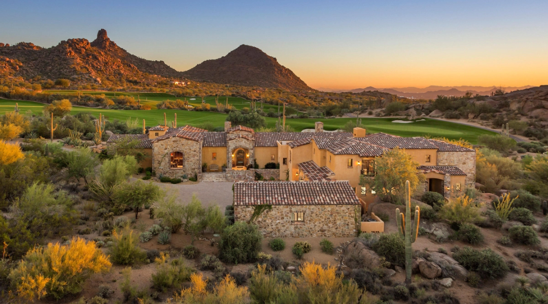 Low stone homes below a granite outcrop in Estancia, warm light at dusk