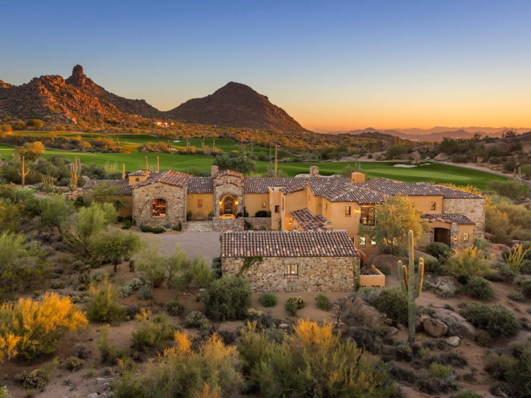 Low stone homes below a granite outcrop in Estancia, warm light at dusk