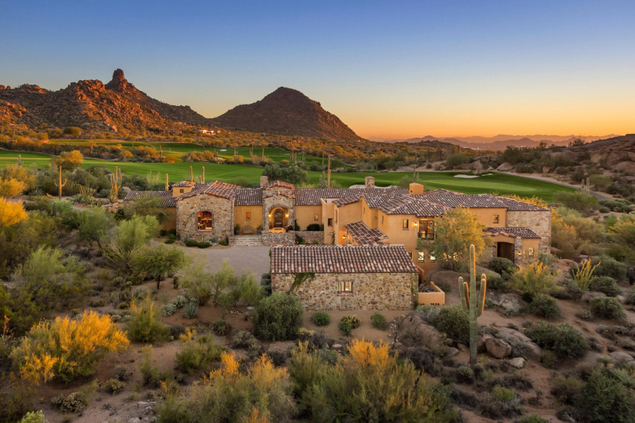 Low stone homes below a granite outcrop in Estancia, warm light at dusk