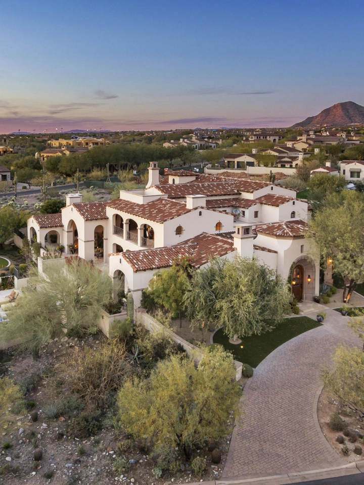 Tile-roofed Andalusian homes in Silverleaf at dusk, the McDowell Mountains behind them