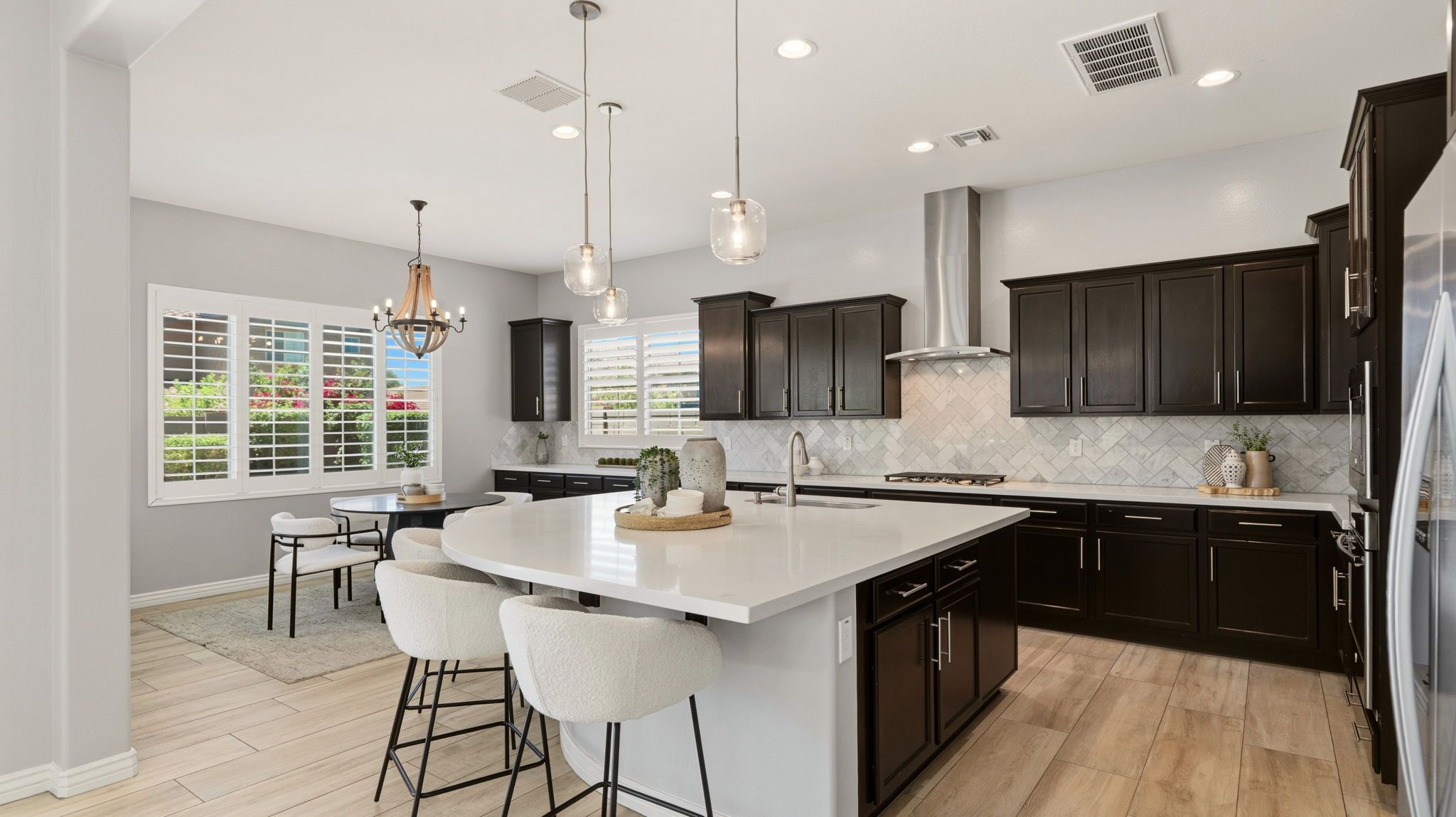 Vista Bonita kitchen with dark cabinetry, quartz countertops, gas cooktop, and curved social island