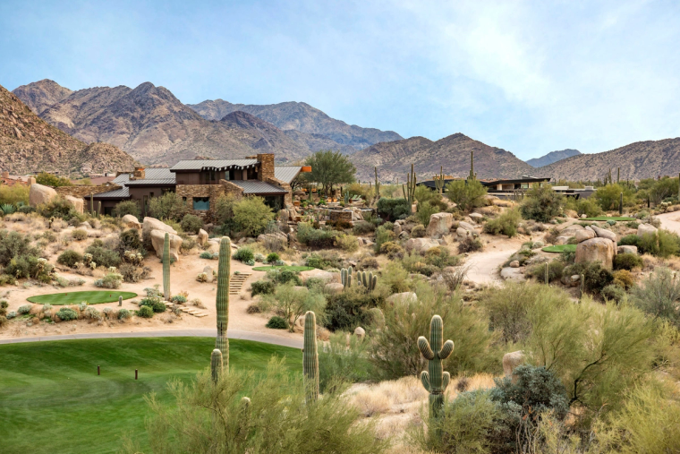 A single low desert-contemporary home set far back in open Sonoran desert, mountain ridge behind it
