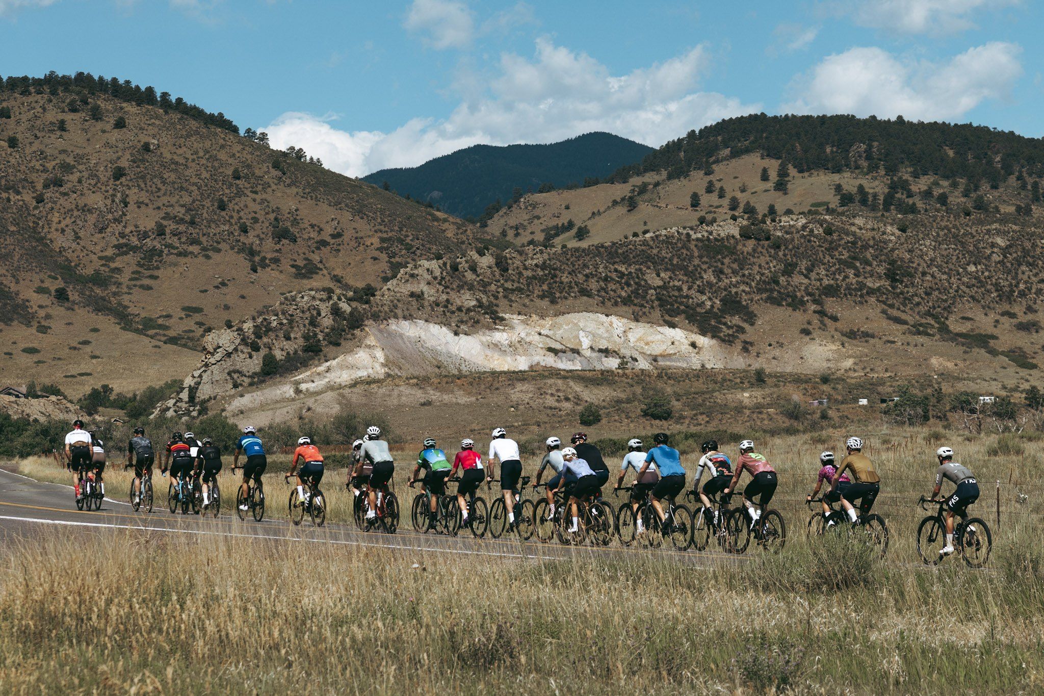 group road cycling through mountain valley