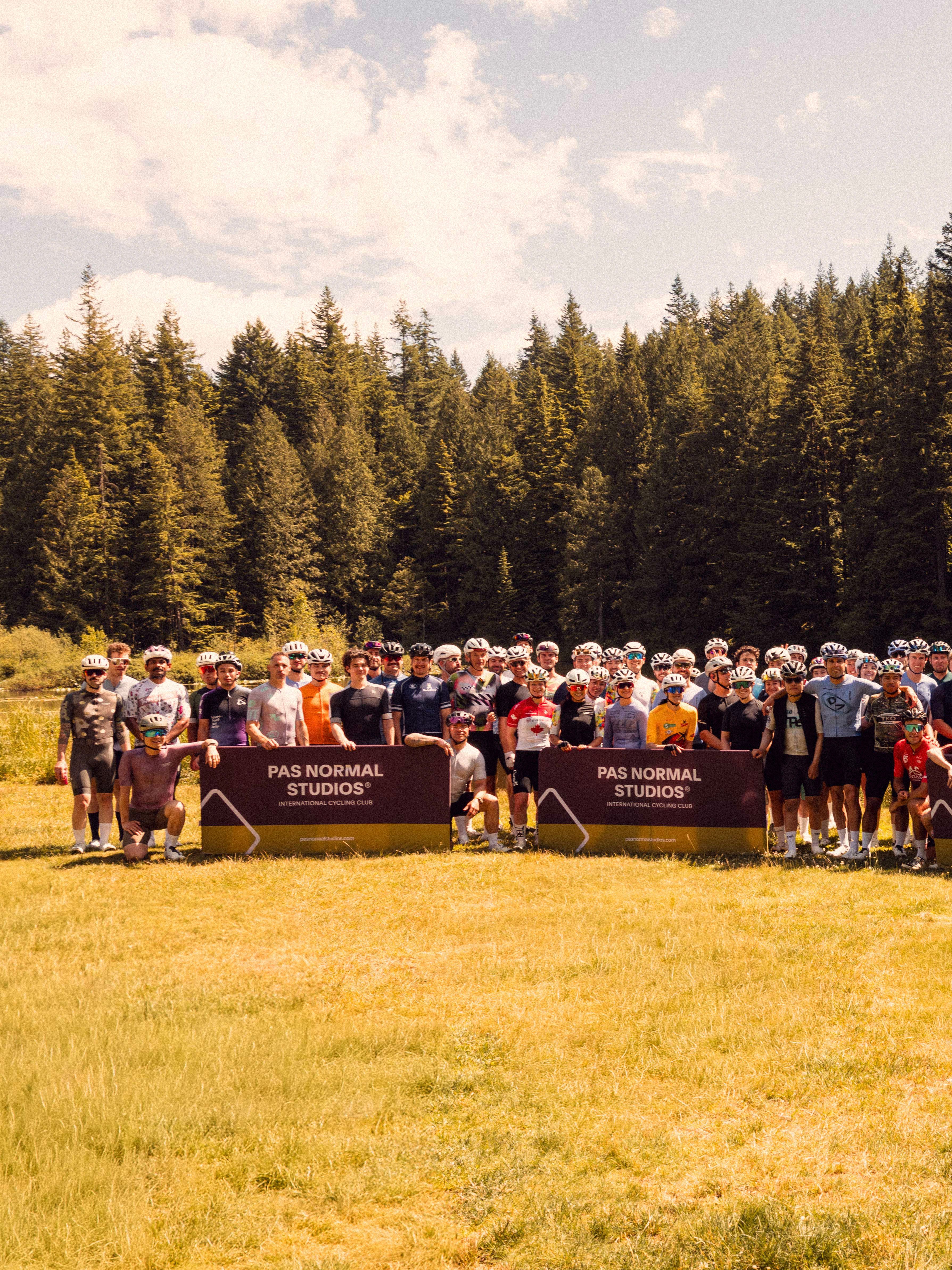 Group of Cyclists standing in front of Pas Normal Studios Banners