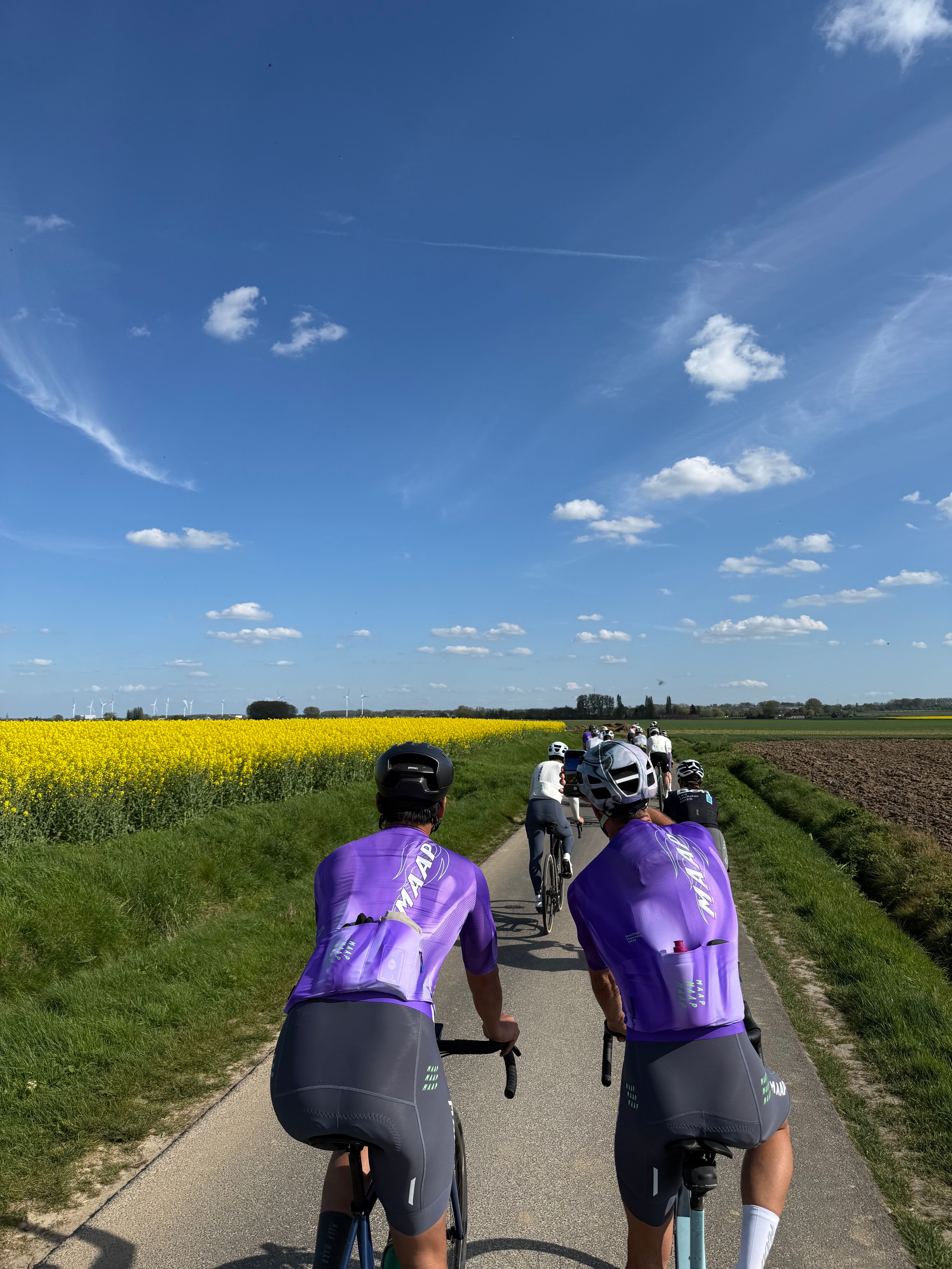 Cyclists in MAAP Apparel with flowered fields in the background