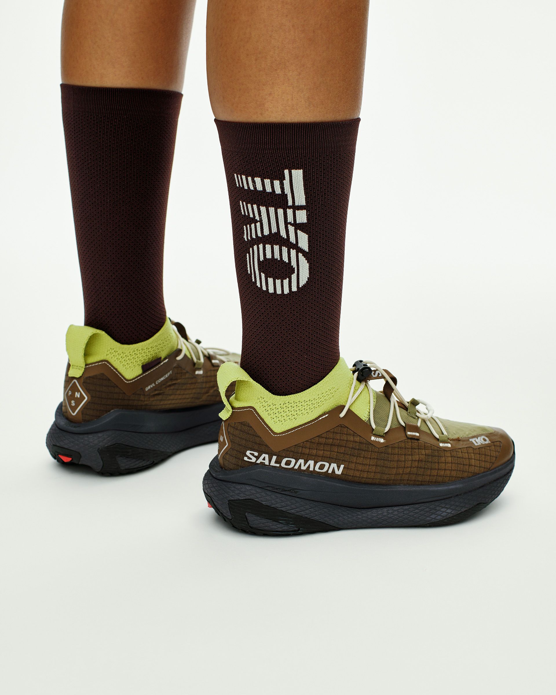 T.K.O. Gravel Concept 2 on-foot heel view showing knit collar, QuickLACE system and Salomon branding on the heel counter