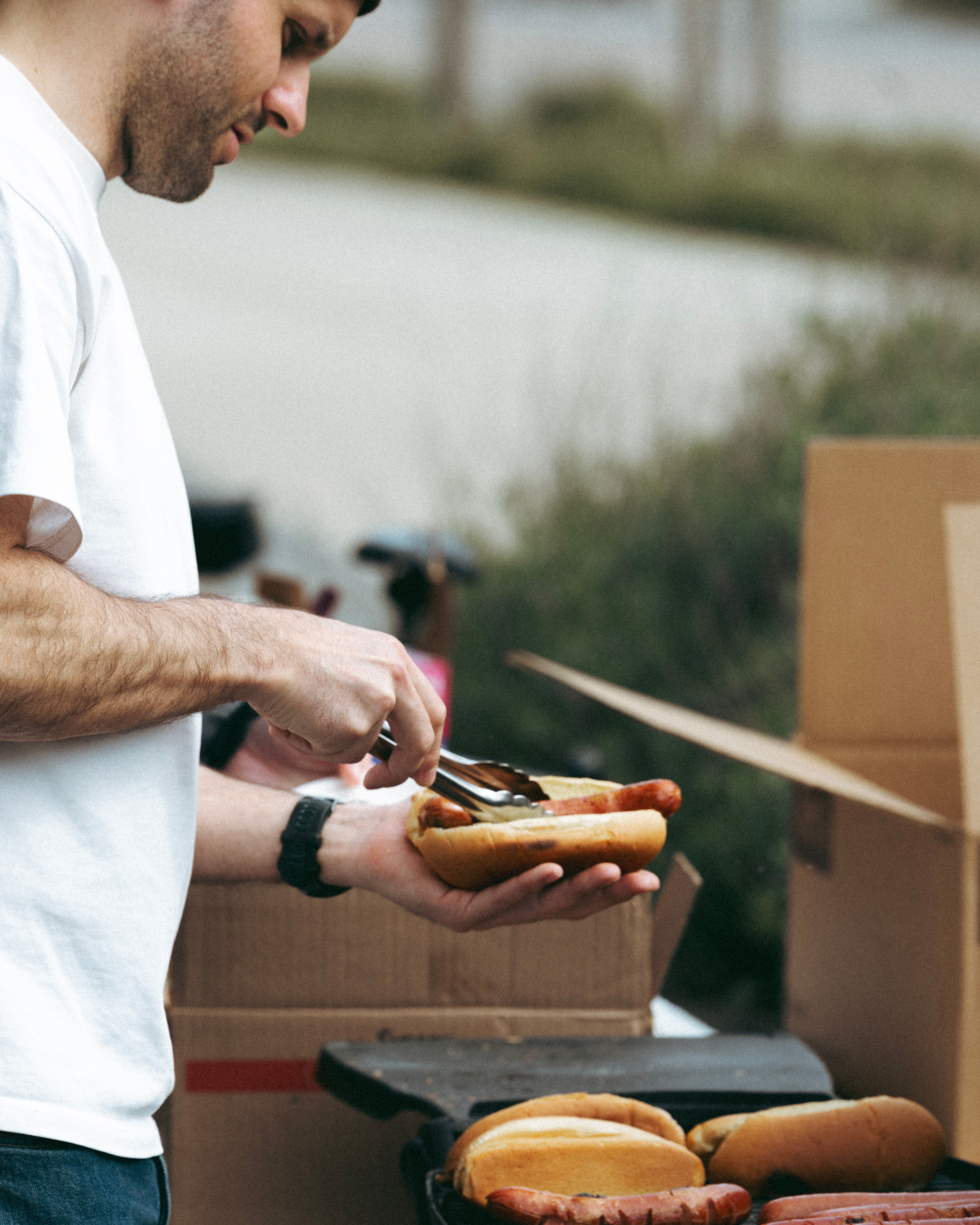 man barbecuing hotdogs