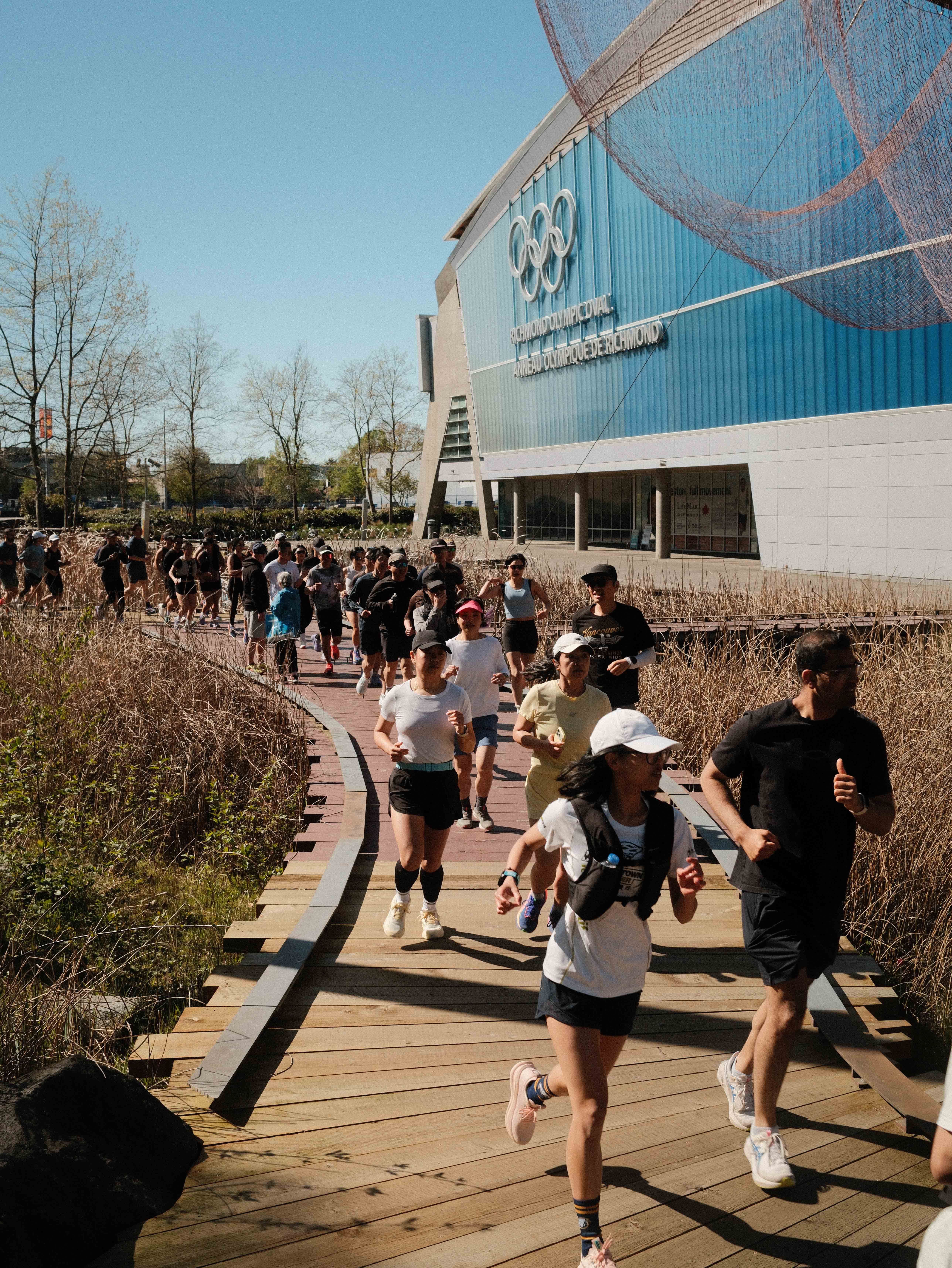 Runners running in front of the Richmond Olympic Oval with Enroute.run