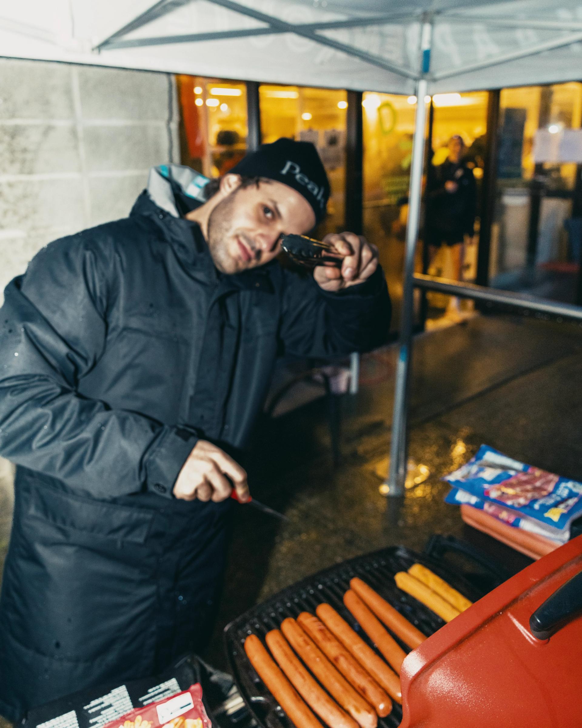 Man Grilling Hotdogs outside of Enroute.CC