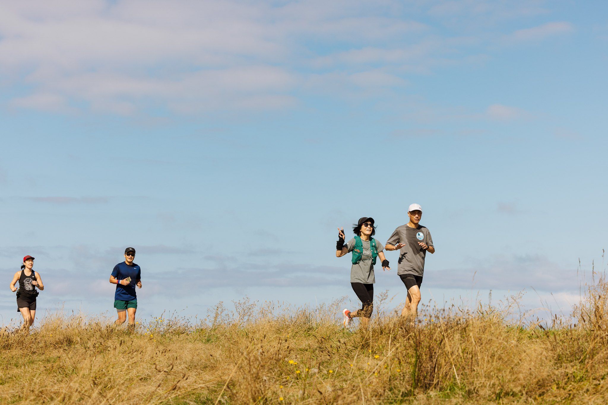 Trail runners jogging through grassland