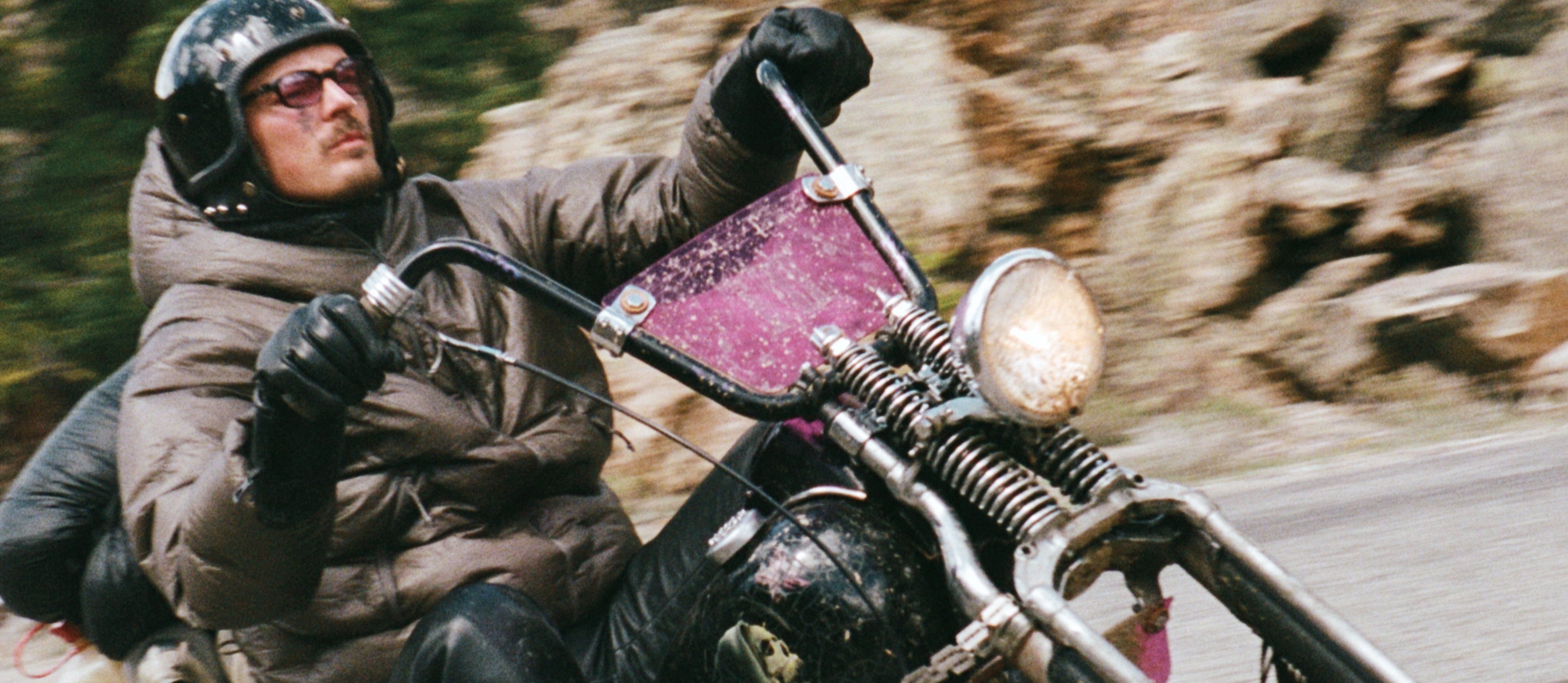 Rider in a Satisfy Rippy Force puffer on a mountain road