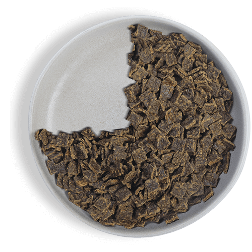 a white bowl filled with brown pieces of food on a black background