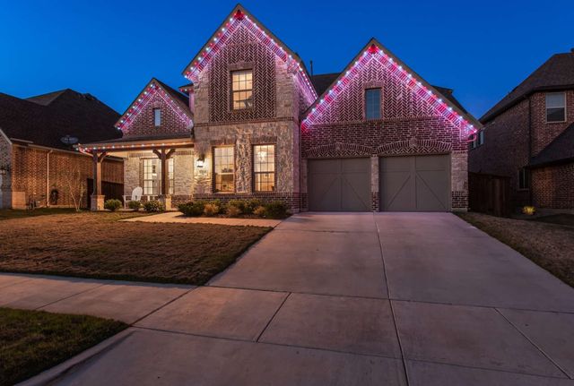 A brick home lit in red, white and blue at dusk