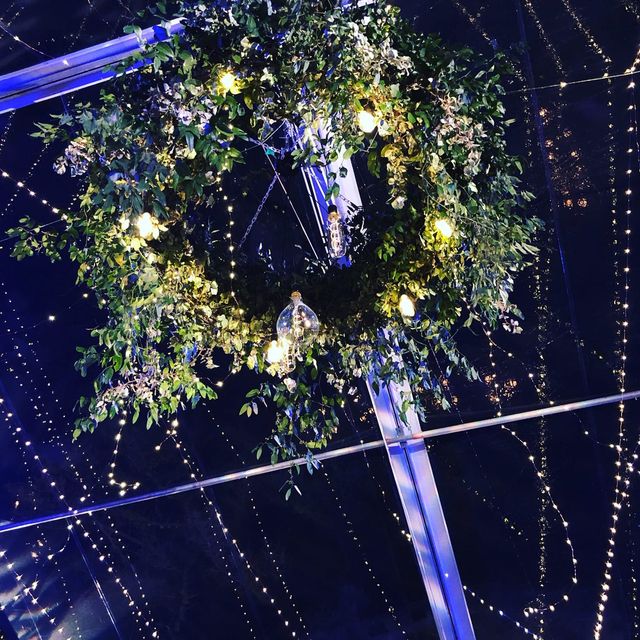 Detail of a lit wreath and twinkle lighting overhead