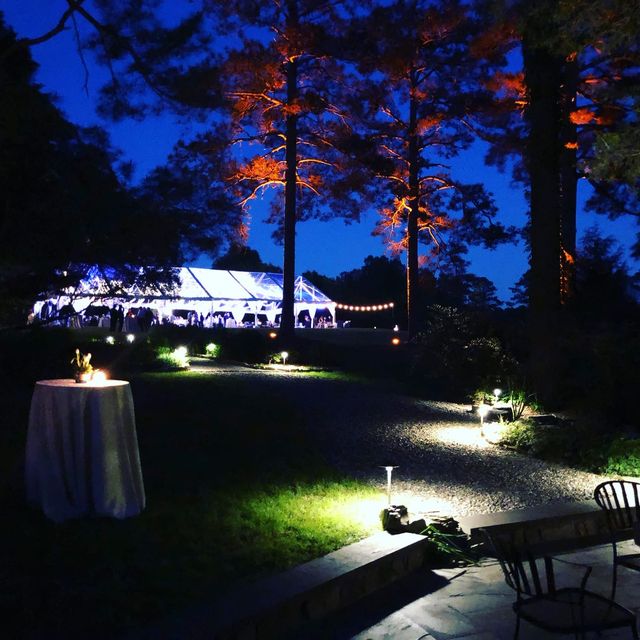 A tented reception lit at blue hour