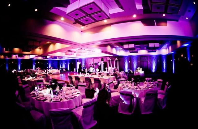 A ballroom washed in purple uplighting for a reception