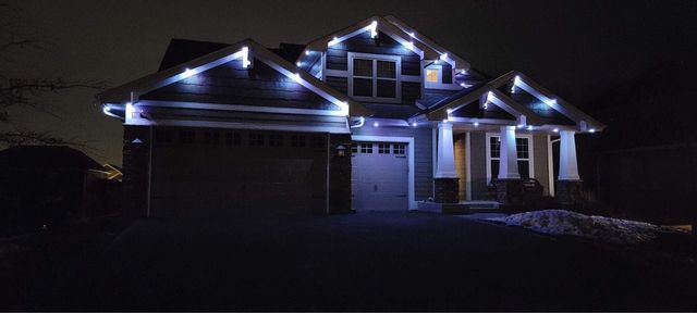 Cool white down lighting over a craftsman driveway