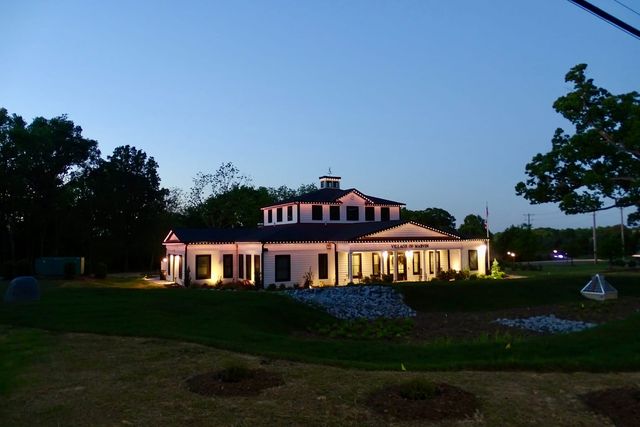A civic building outlined in warm white at blue hour