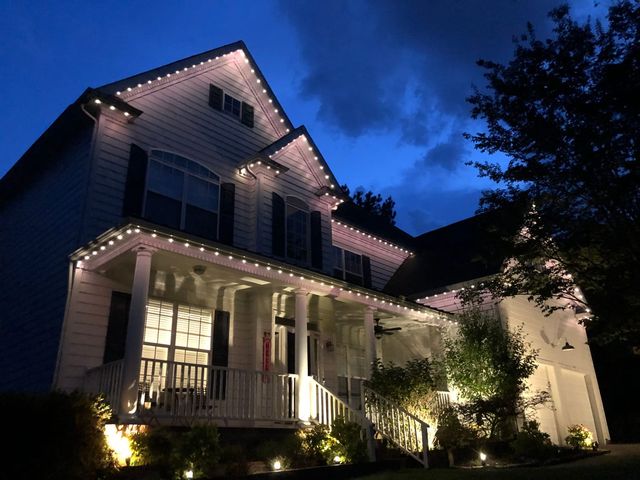 Down lighting washing a white farmhouse porch